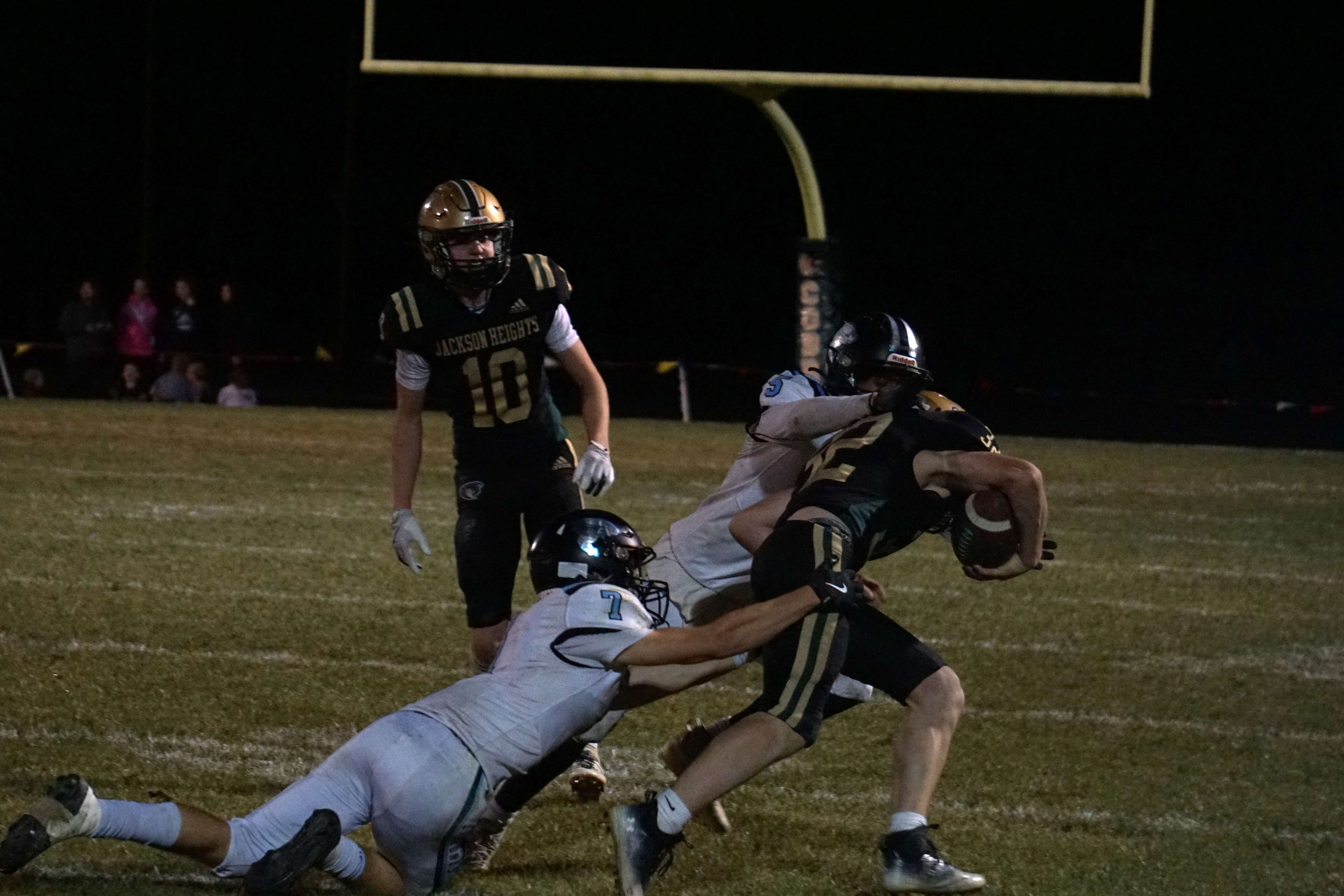 Chase Hewins (7) and Ty'Zell Harrington (5) fight to bring down Tatum Eisenbarth (32)/ Photo by Matt Pike