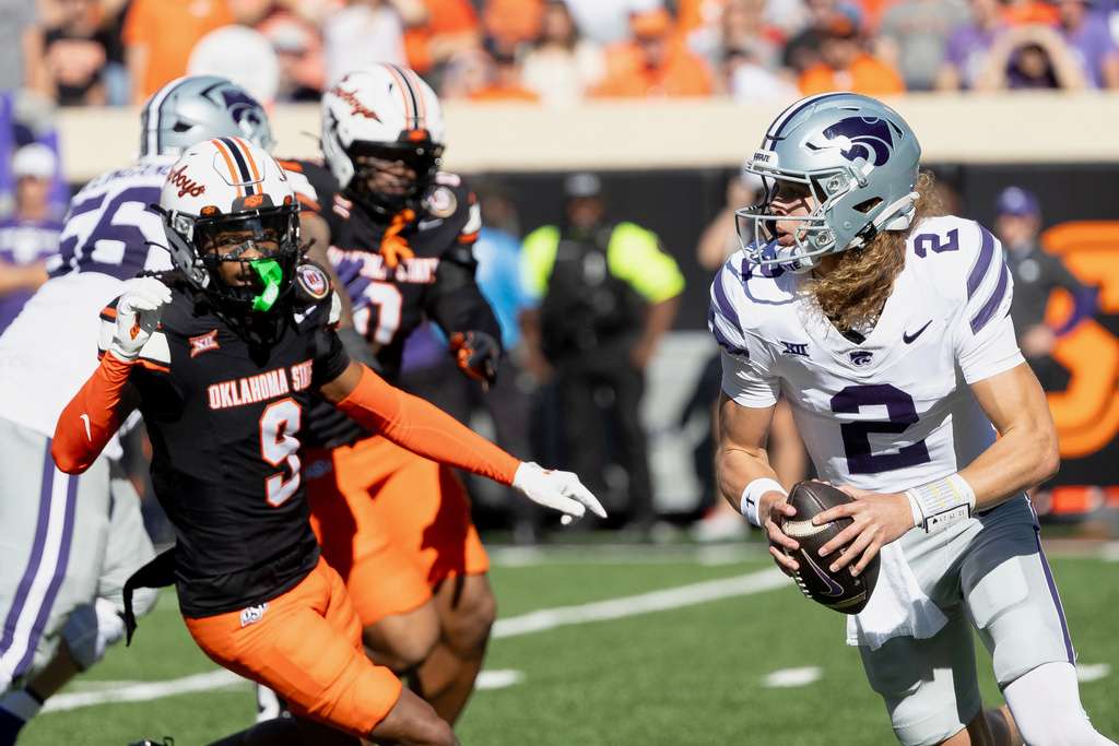 Kansas State quarterback Avery Johnson (2) runs past Oklahoma State cornerback Ladainian Fields (9) in the first half of an NCAA college football game Saturday, Nov. 15, 2025, in Stillwater, Okla. (AP Photo/Mitch Alcala)