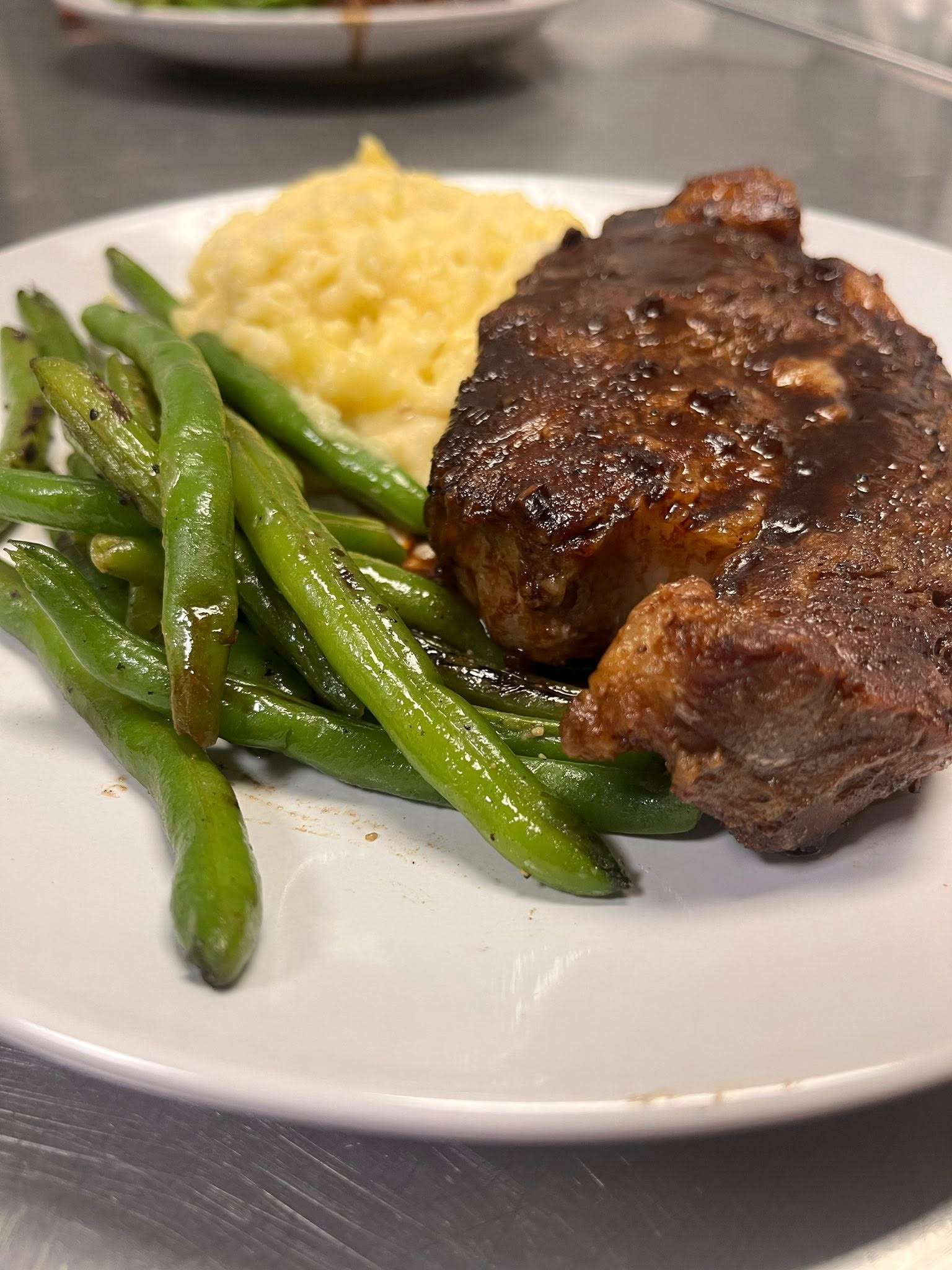 Ribeye steak served with green beans.