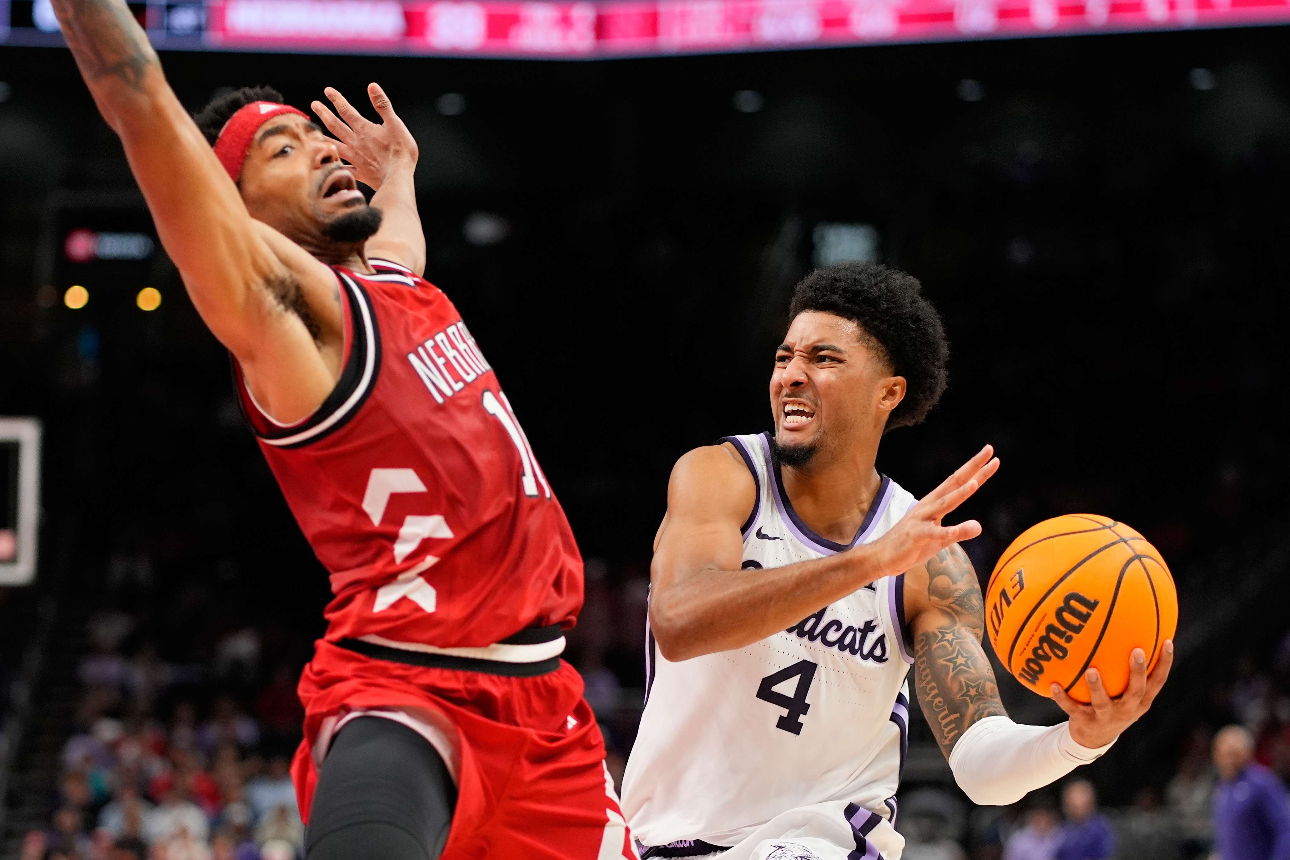 Kansas State guard P.J. Haggerty (4) looks to pass around Nebraska guard Jamarques Lawrence (10) during the first half of an NCAA college basketball game Friday, Nov. 21, 2025, in Kansas City, Mo. (AP Photo/Charlie Riedel)