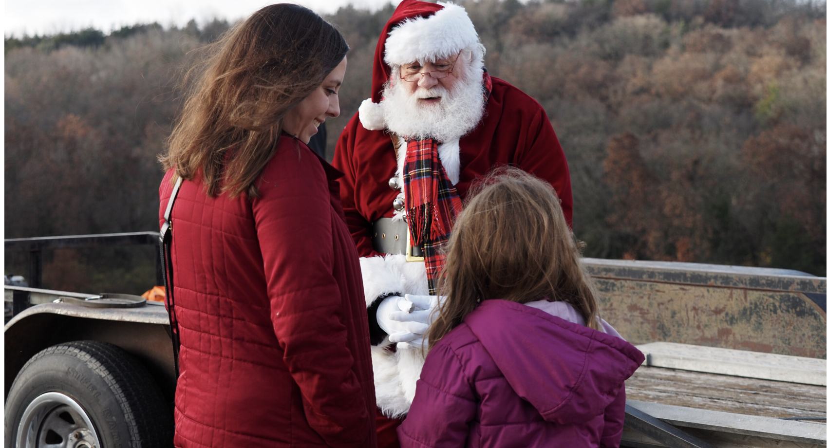 Charlotte Cooper tells Santa she hasn’t quite completed her Christmas list at the governor’s Christmas tree donation on Nov. 25, 2025, at Cedar Crest in Topeka. (Photo by Grace Hills for Kansas Reflector)
