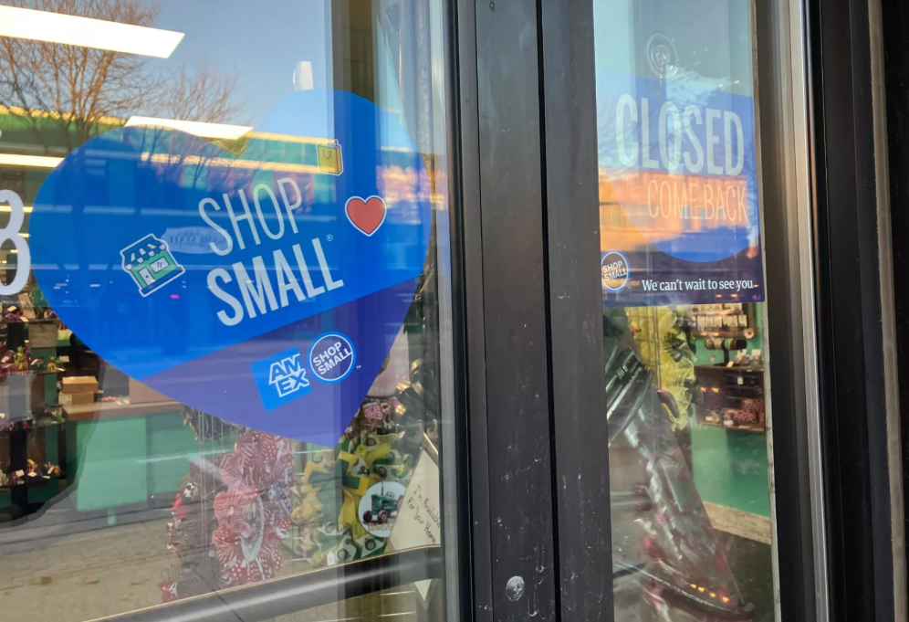 A sign posted on a business door in Spencer, Iowa, asks people to "shop small." Nearly half of U.S. small businesses who responded to a national survey said profits fell this autumn. Photo by Rachel Cramer/Harvest Public Media