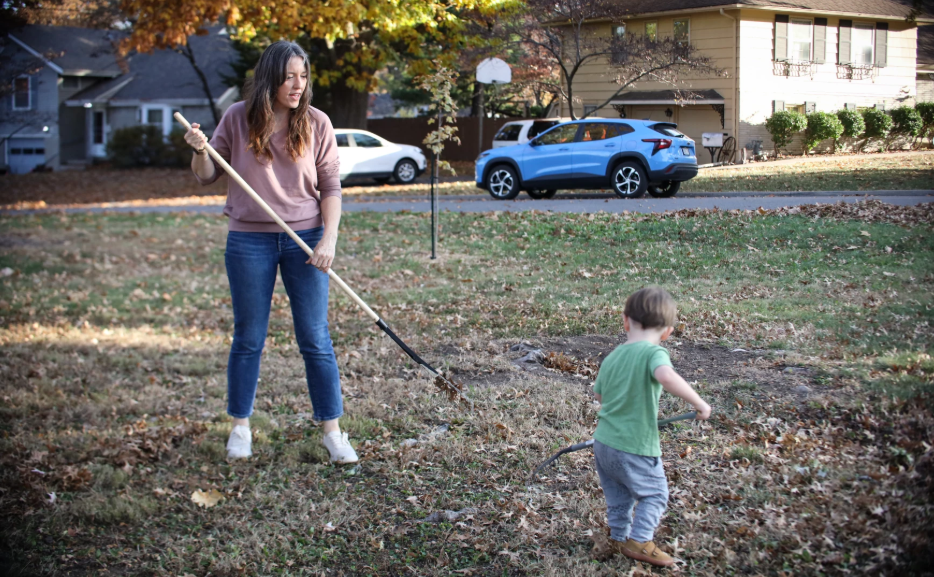 Annie Parsons and her son, River, rake leaves in their Roeland Park yard. Photo by Beck Shackelford-Nwanganga/Kansas News Service