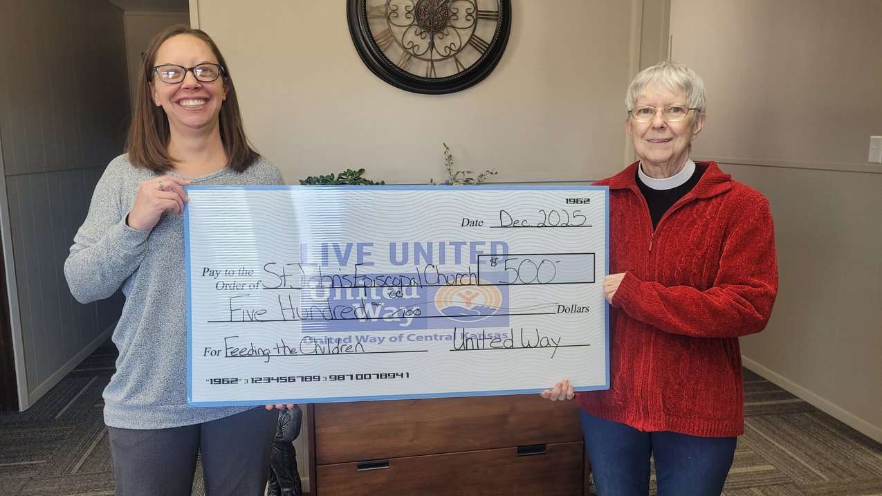 United Way of Central Kansas Executive Director Charell Owings presents Rev. Teresa Lahar and St. John's Episcopal Church with a check.