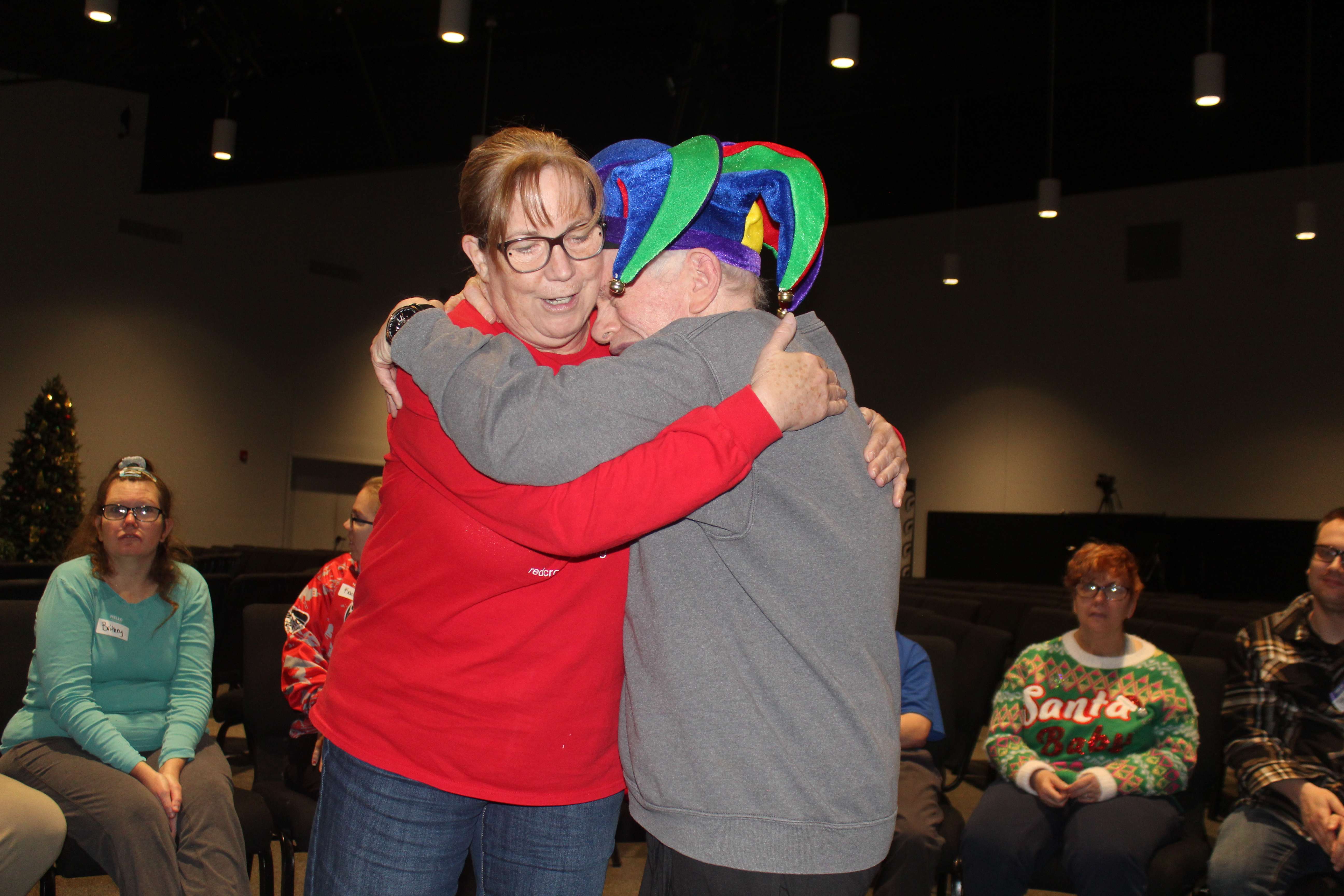 A camper receives a hug from a camp volunteer. Photo by Cristina Janney/Hays Post