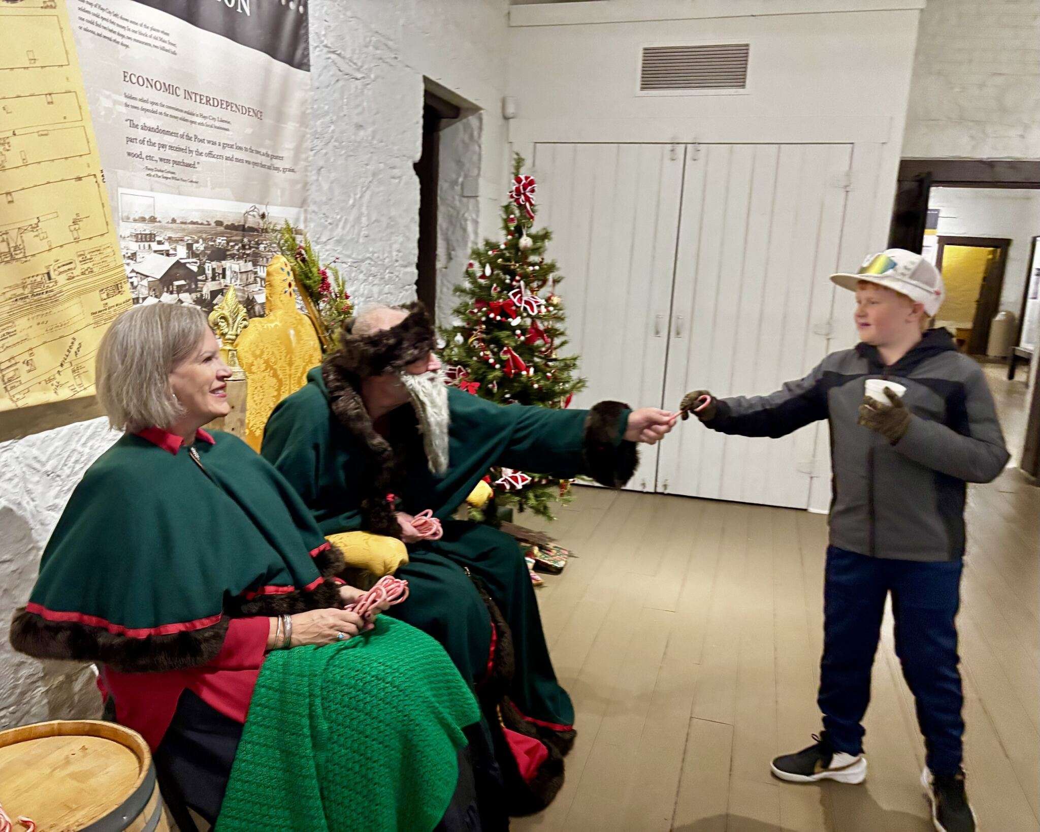 An attendee at Christmas Past Open House at Historic Fort Hays being handed a candy cane by Father Christmas. Photo by Tony Guerrero/Hays Post