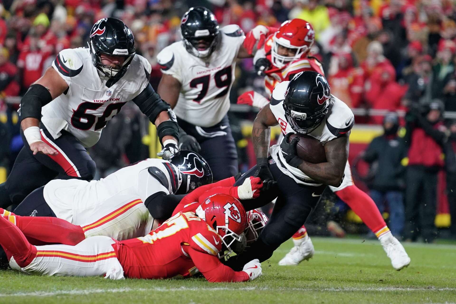 Houston Texans running back Dare Ogunbowale, right, scores past Kansas City Chiefs defensive back Chamarri Conner during the second half of an NFL football game Wednesday, Jan. 7, 2026, in Kansas City, Mo. (AP Photo/Ed Zurga)