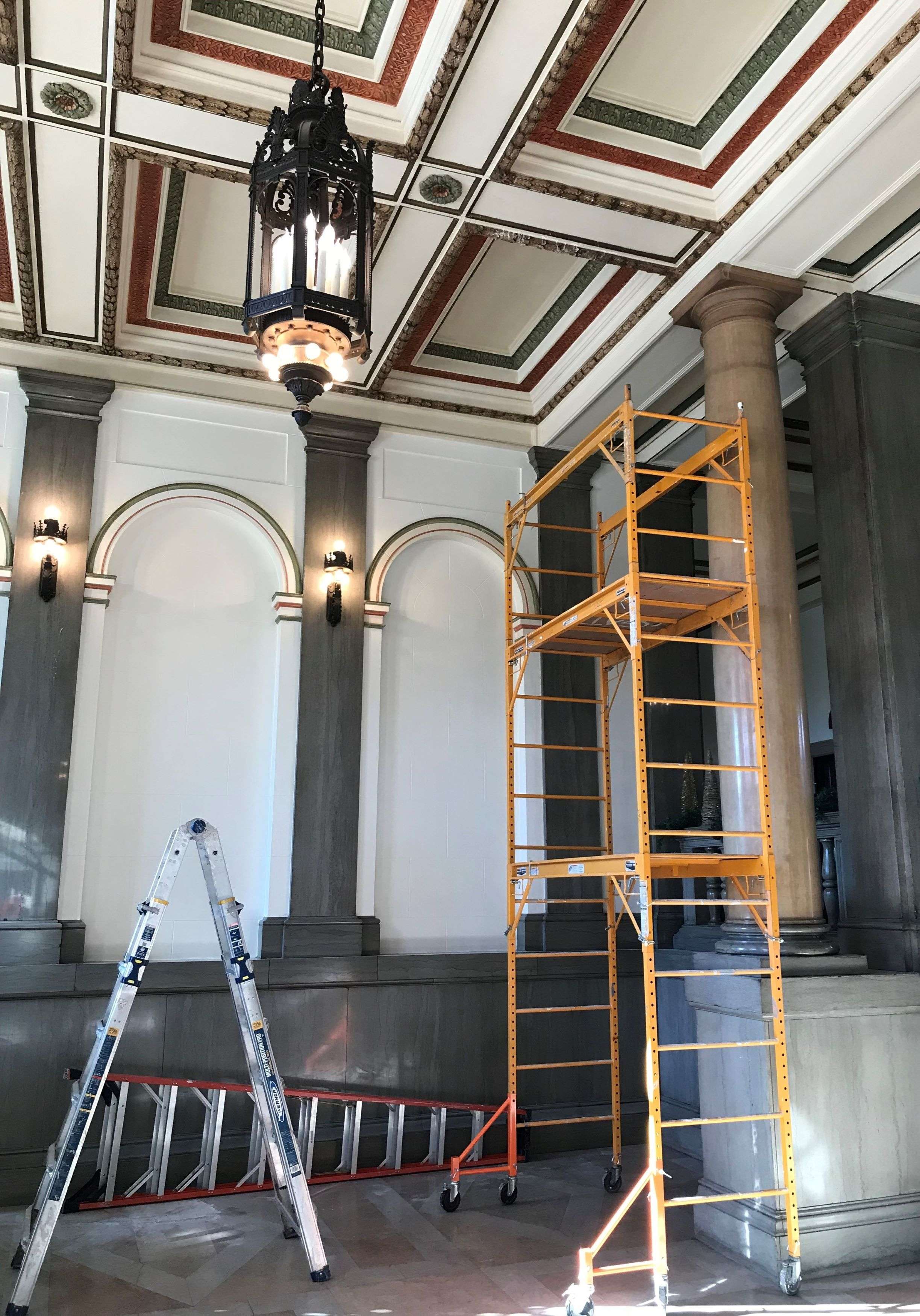 Painters are restoring the original color scheme on the ceilings of City Hall/Photo by Brent Martin