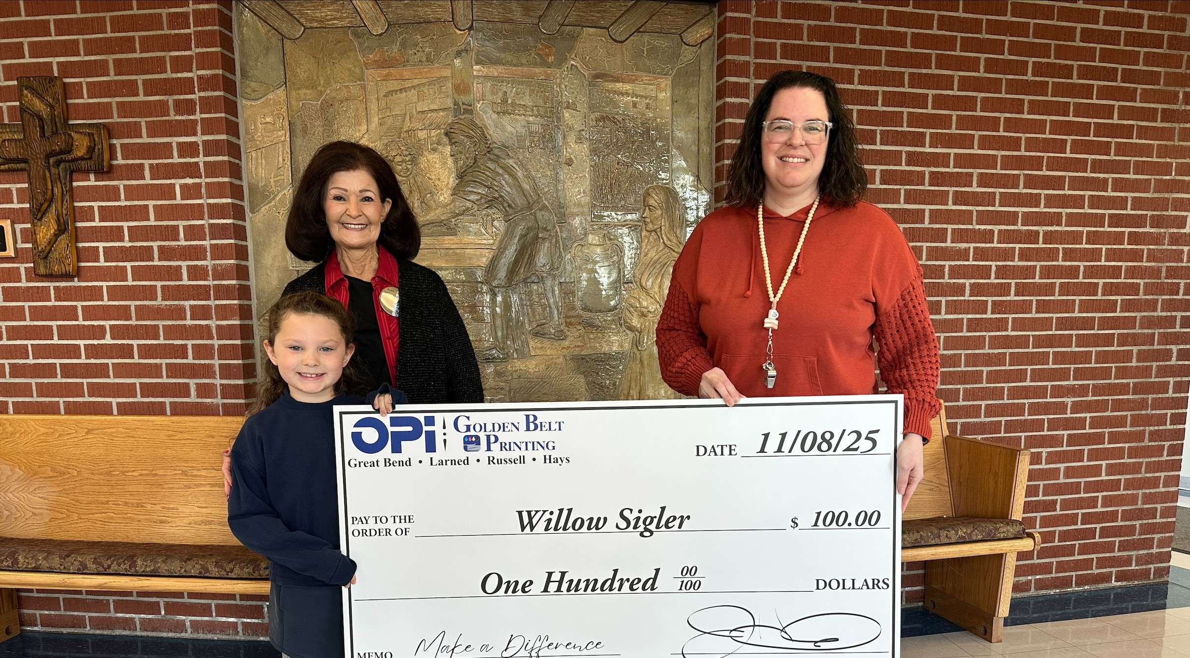 Holy Family first grader Willow Sigler was recently presented a $100 check from OPI &amp; Golden Belt Printing as the latest winner in Eagle Media's Make a Difference contest. Willow and her teacher, Mrs. Davis, are now eligible for the December monthly prize.