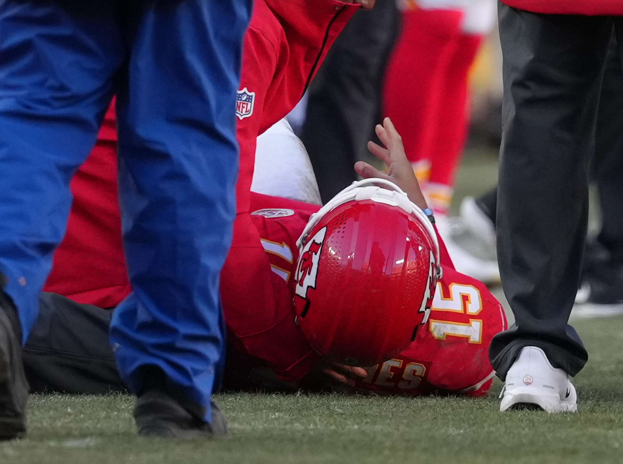 Kansas City Chiefs quarterback Patrick Mahomes (15) is checked on after being injured during the second half of an NFL football game against the Los Angeles Chargers Sunday, Dec. 14, 2025, in Kansas City, Mo. (AP Photo/Ed Zurga)