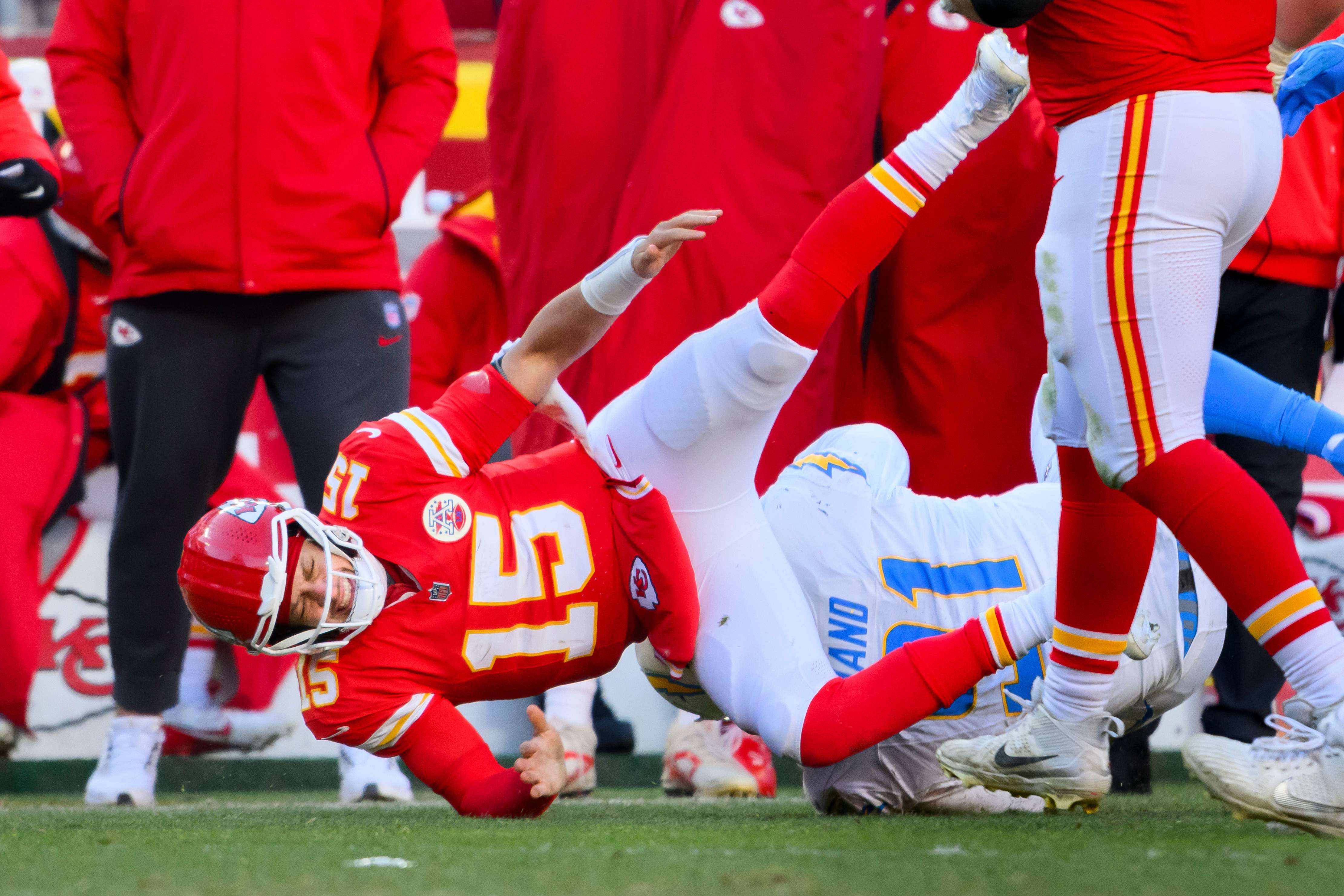 Los Angeles Chargers defensive tackle Justin Eboigbe (92) checks on Kansas City Chiefs quarterback Patrick Mahomes (15) as Chiefs head coach Andy Reid, center, looks on after Mahomes was injured during the second half of an NFL football game, Sunday, Dec. 14, 2025 in Kansas City, Mo. (AP Photo/Reed Hoffmann)