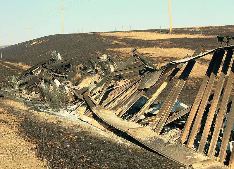 A semi-truck that was blown over on Kansas Highway 18 near Paradise during the wind storm was caught in a wildfire. Local law enforcement said no was injured. Photo by Cristina Janney/Hays Post