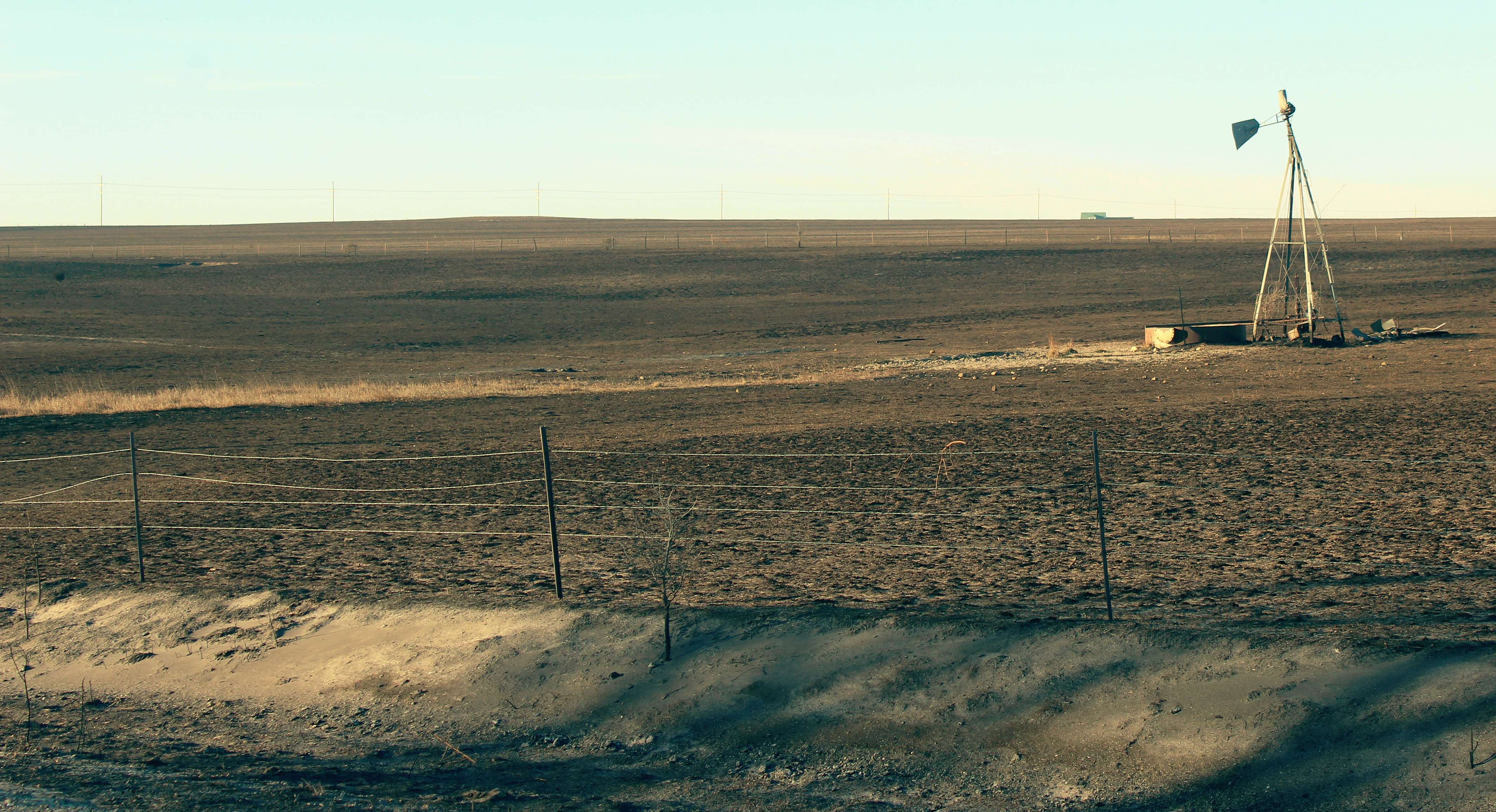 A windmill stands alone against the burnt landscape off of Codell Road in northeast Ellis County. Photo by Cristina Janney/Hays Post