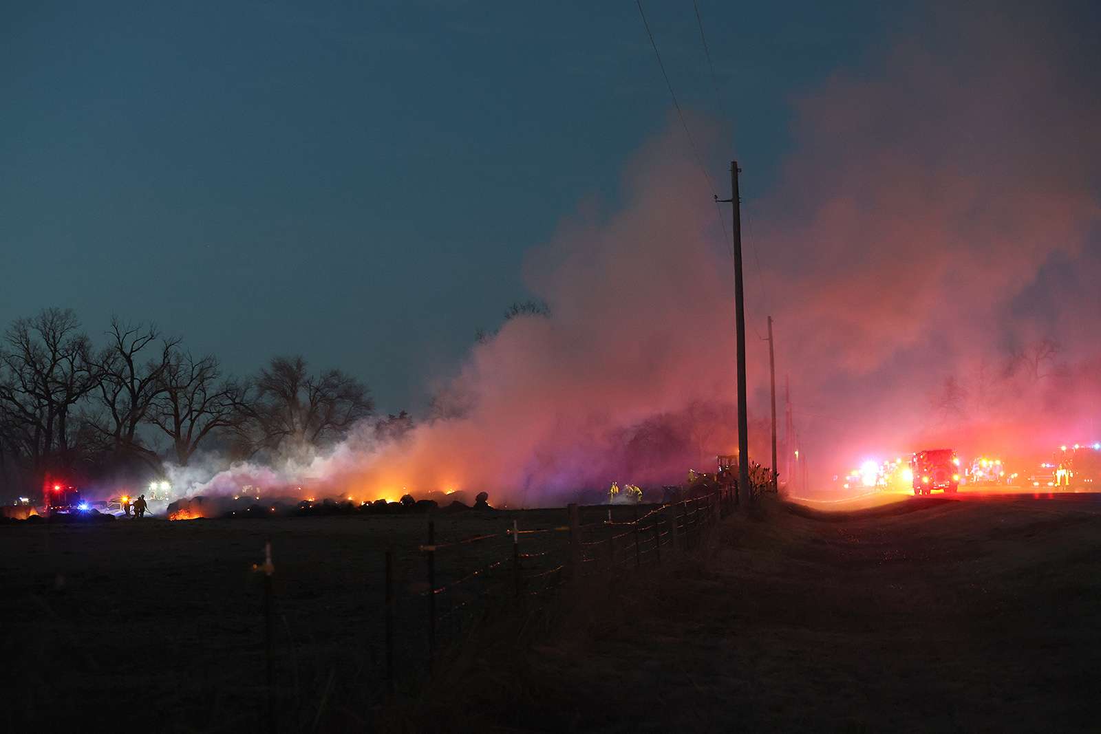 Firefighters continue to put out burning bales of hay Thursday evening west of Plum Street near 69th&nbsp;Avenue. (Photo courtesy Sandra Milburn)