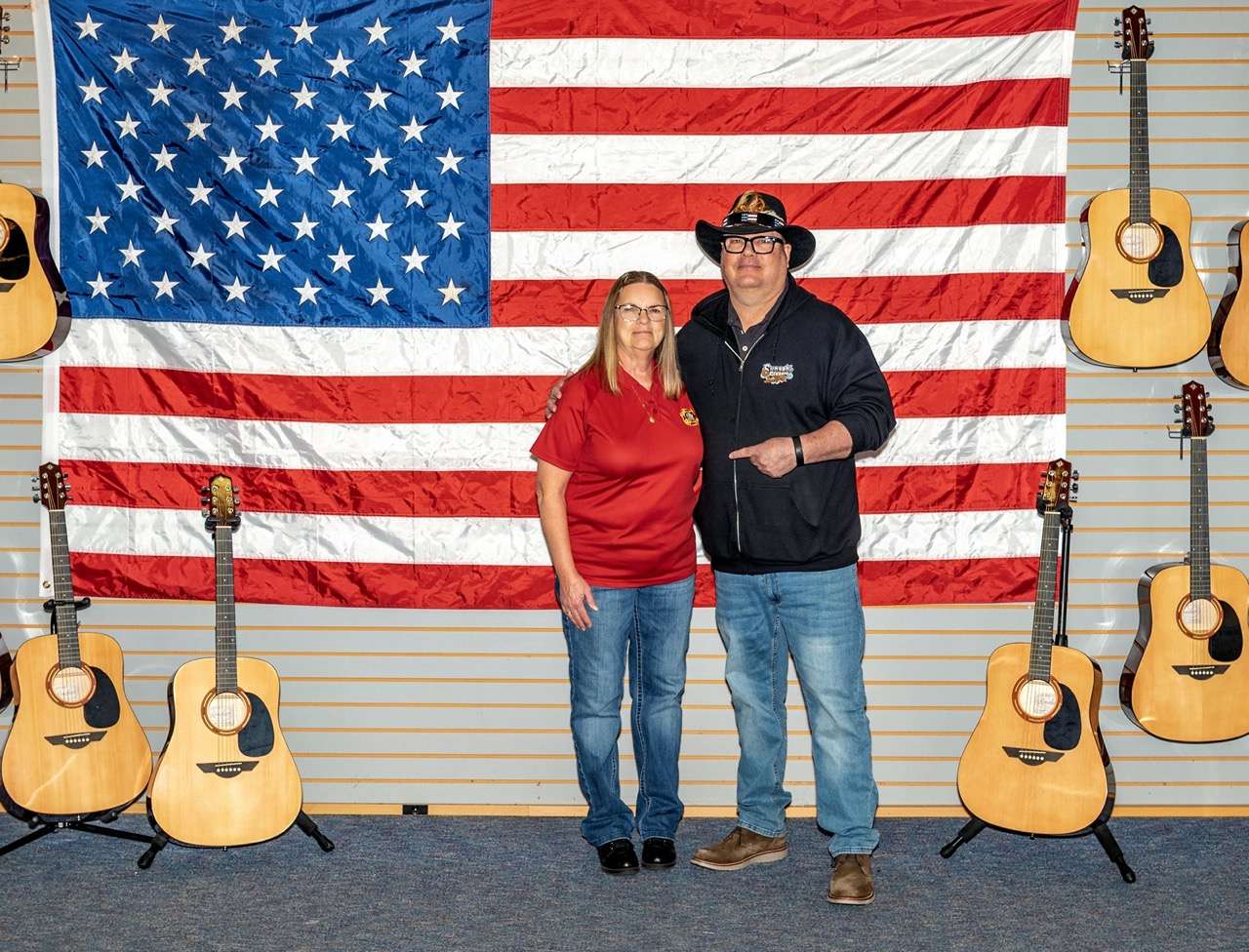 Kathy McCandless and Blake Blackim at Midwest Music (210 S Santa Fe) with the guitars that are slated to be given to US Veterans at the VFW National Home. Photo by Jeff Haines