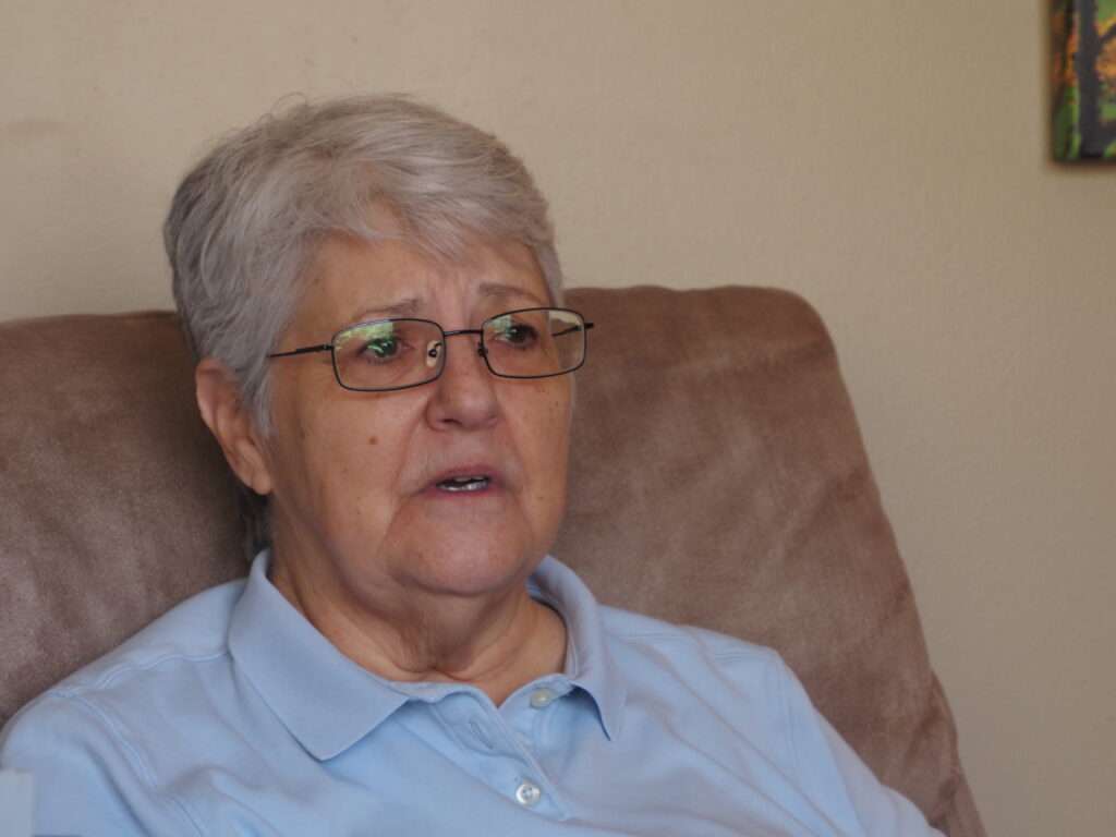 Tina Thompson on Dec. 19, 2025, in her home in Lawrence, recounts how her family influenced her faith. The Catholic Church has always been a part of her, she says. (Photo by Anna Kaminski/Kansas Reflector)