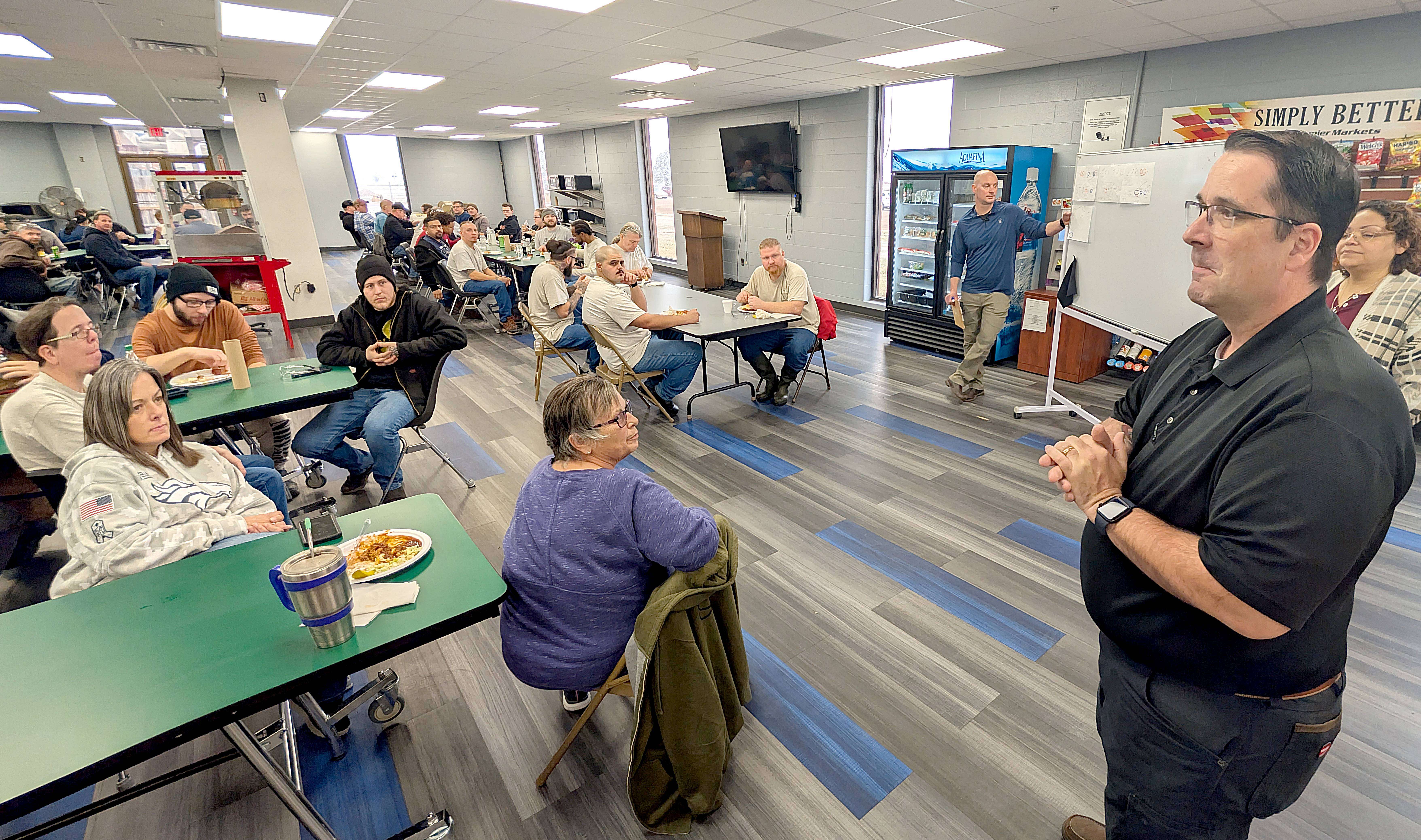 New Fuller Industries Inc. Vice President of Production Chris Cowles addresses an all-building meeting last Wednesday morning in the company’s cafeteria. Cowles started in the position last Monday.