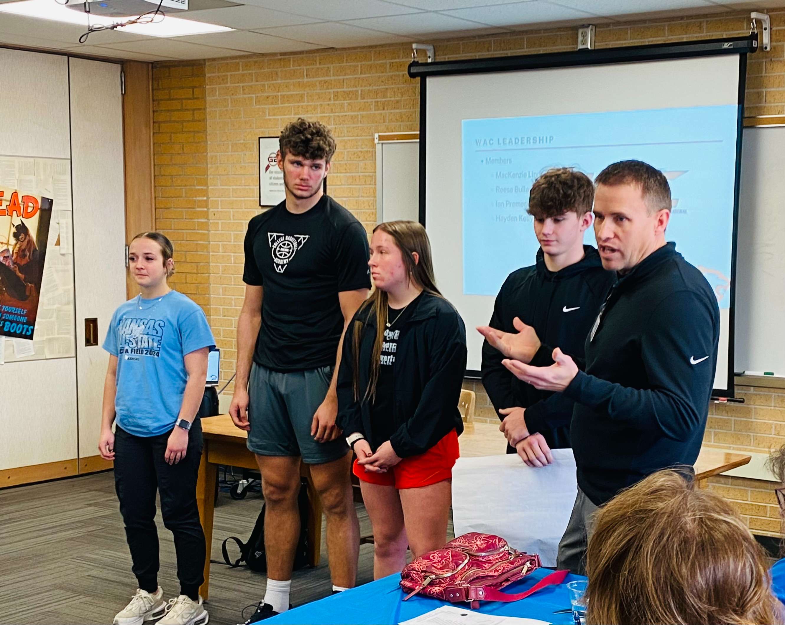 Great Bend High School juniors Reese Bullard, Ian Premer, MacKenzie Lindberg and Hayden Kelly and GBHS Activities Director Matt Westerhaus present on WAC Leadership at the USD 428 Board of Education luncheon at GBHS on Wednesday, Feb. 26, 2025.