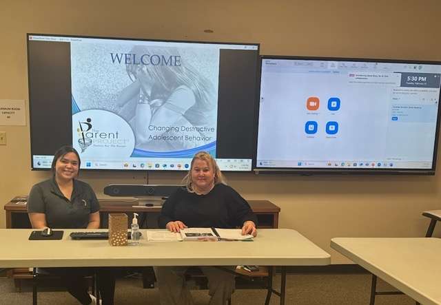 Paulina Martinez, left, and Casey Rowland prepare for a session of Parent Project with new tele-health equipment at Juvenile Services (JS). Martinez is case manager and Rowland is family engagement advocate at JS, which offers Parent Project.