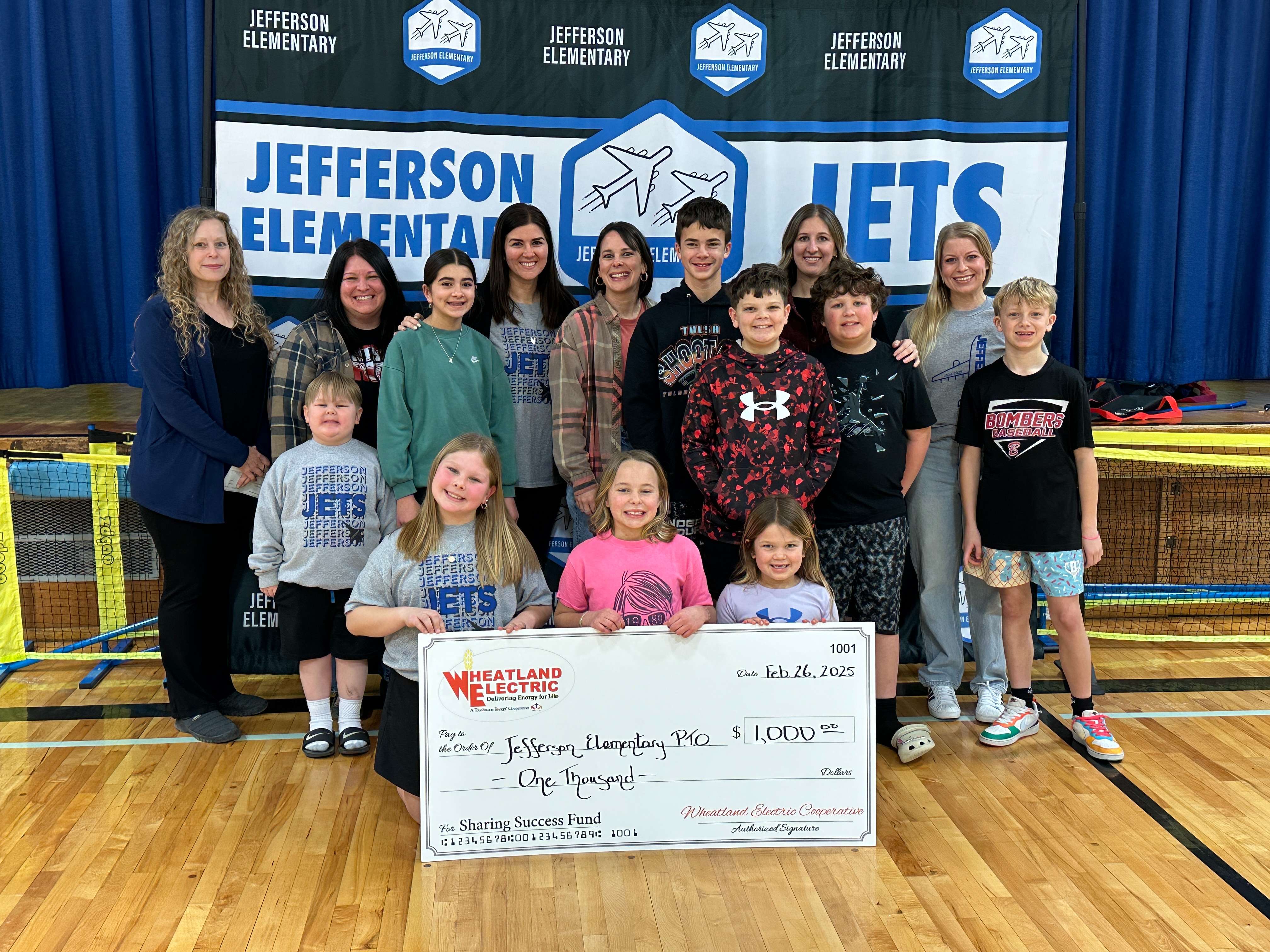 Jefferson Elementary School PTO and students receive a $1,000 Wheatland Electric Sharing Success grant presented by Mary Hoisington, member services and key accounts manager (far right), to help purchase new equipment for the school’s aging playground.