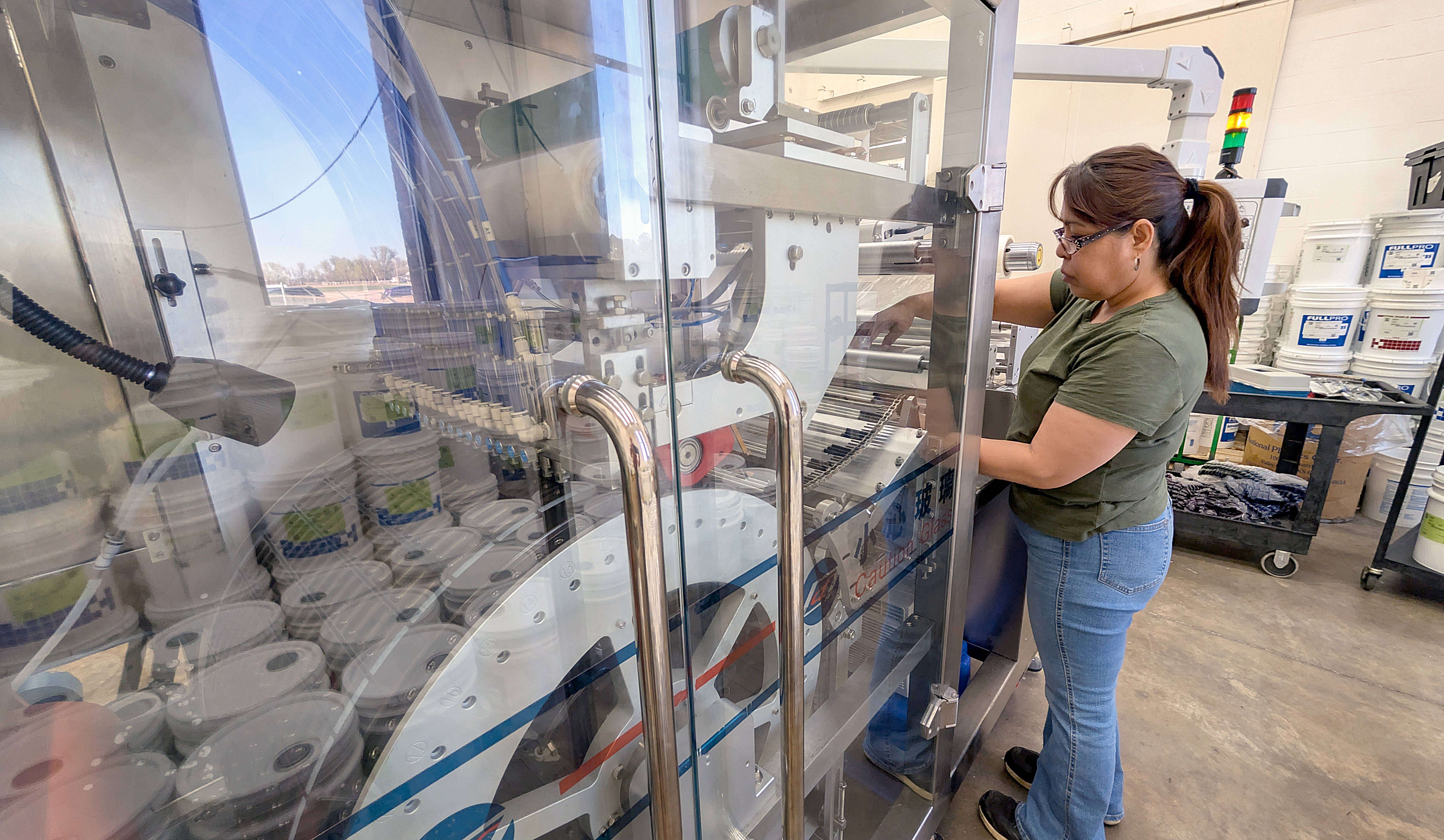 Fuller Industries Inc. employee Maribel Balderrama Monday prepares the new monopod machine to run a batch of cleaner pods. While efficient and can produce 300 pods per minute, the device requires careful attention and calibration.