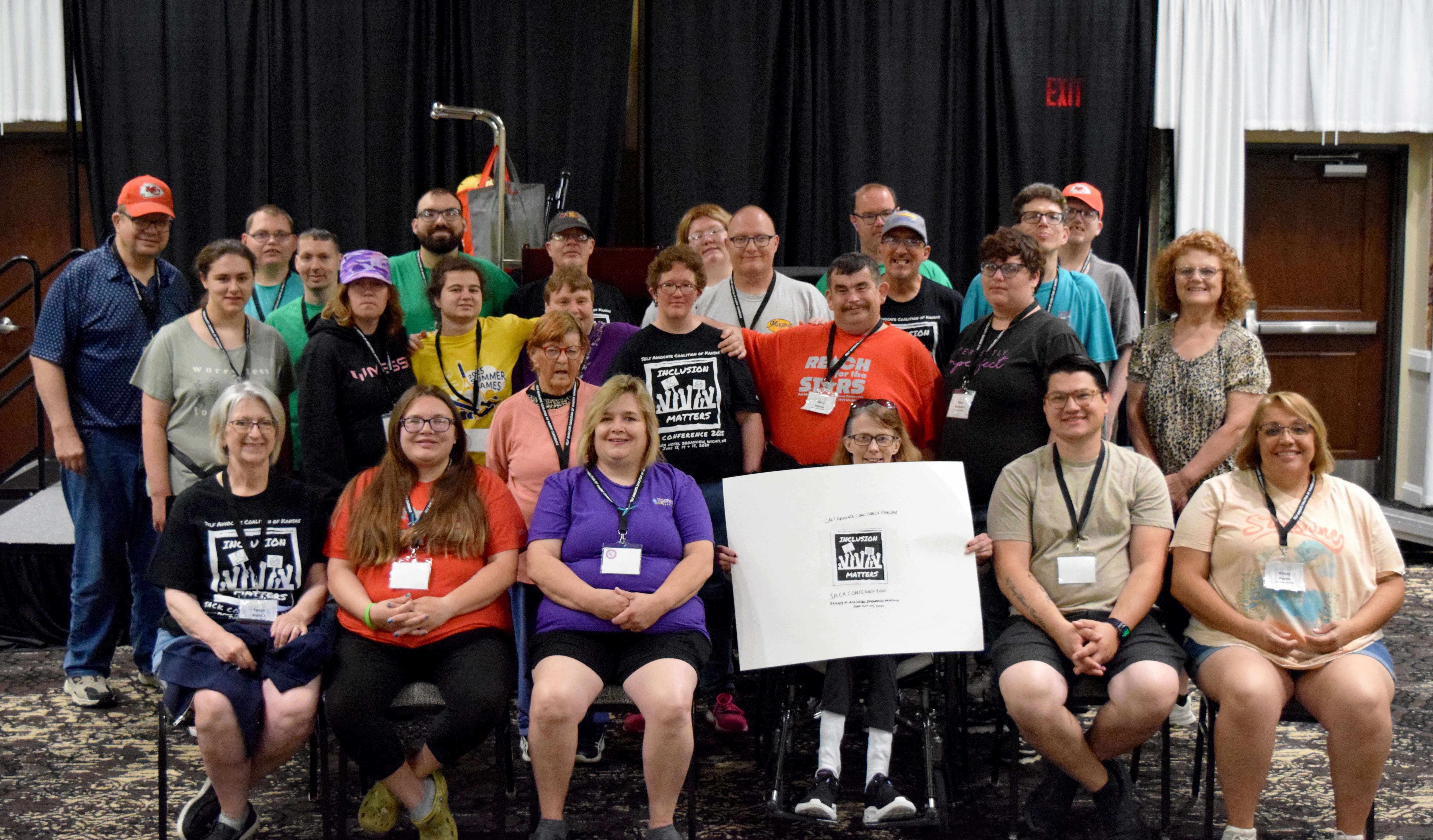 For the second consecutive year, Rosewood Services brought the most representatives to the Self Advocate Coalition of Kansas Conference in Wichita last weekend. Pictured left to right, back row: Ivan Smith, Codie Hardie, Shaun Ledesma, Austin Orozco, David Edwardson, Destiny Thomas, Josh Trimmer, Darren Brown, Michael Manka, Jim West, Johnathan Howe; middle row: Caitlyn Stinger, Shae Griffin, Cierra Roberts, Ella Haberman, Beth Mattocks, Abbey Stanley, Chris Devine, Stacey Buchwald, Jeannie Triplett; front row: Tonya Burton (sponsor), Tahcoa Strachan (staff), Frankie Pelster (sponsor), Pam Babcock, Joe Smeragliulo (staff), and Kristy Perez (staff)&nbsp;