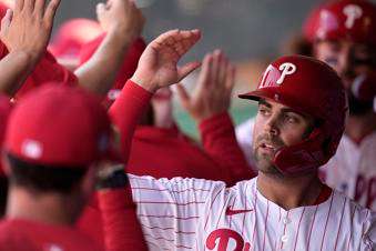 FILE - Philadelphia Phillies' Whit Merrifield celebrates with teammates after scoring during the fourth inning of a spring training baseball game against the Atlanta Braves, Feb. 28, 2024, in Clearwater, Fla. (AP Photo/Charlie Neibergall, File)