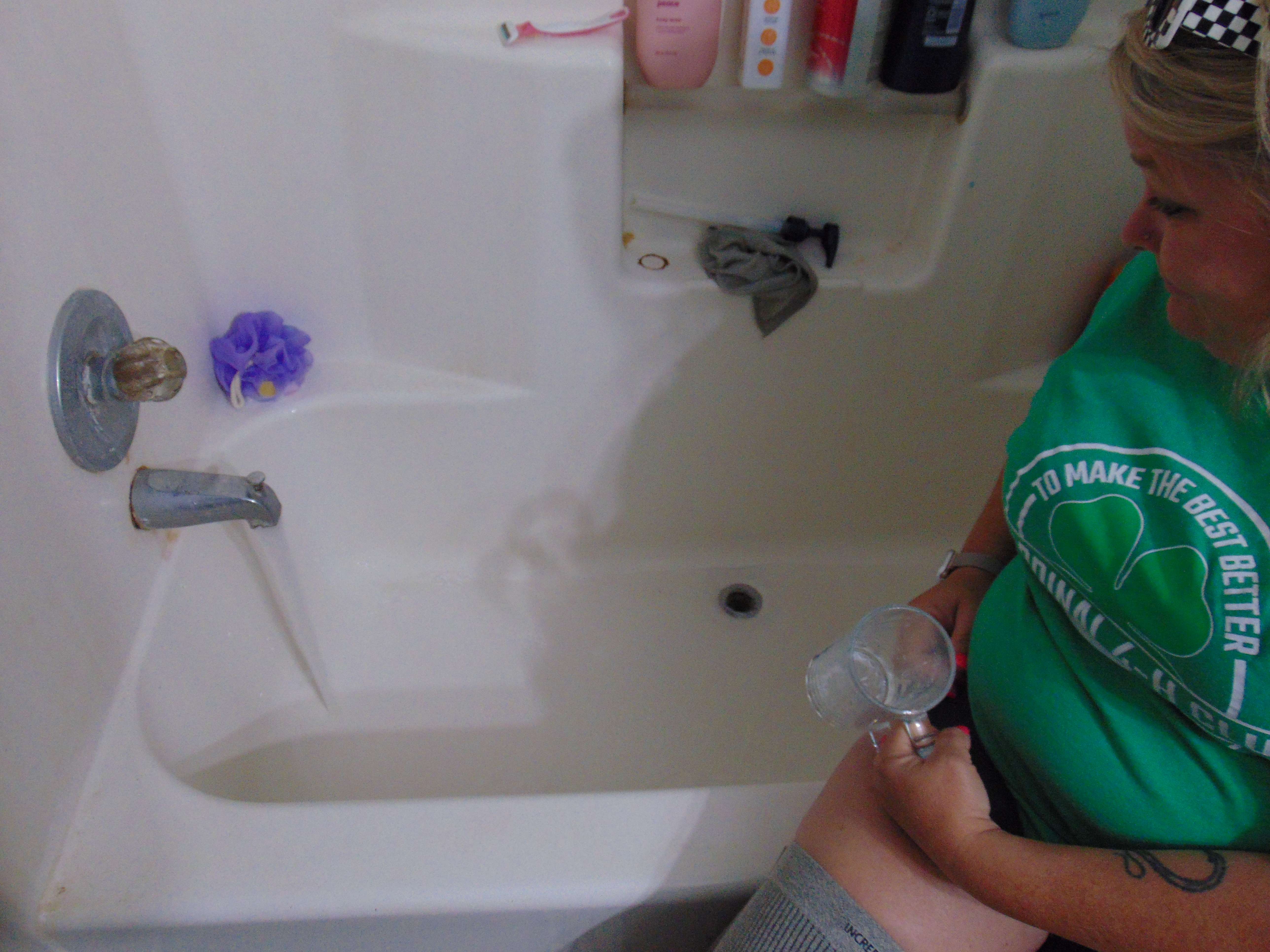 Sundowner West Mobile Home Park resident, Misty Livingston-Holmes watching her shower faucet release water as 'black chunks' would occasionally come forth. Photo by Nicolas Fierro (taken June, 2025)