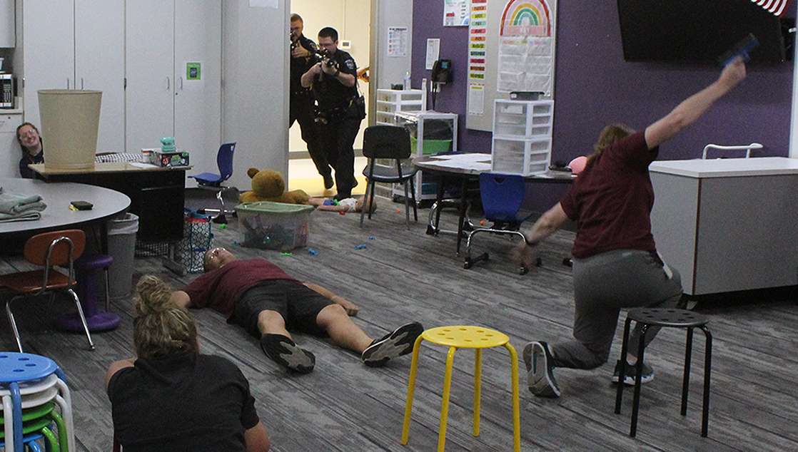 Officers breach a classroom during an active shooter training exercise at Roosevelt Elementary School on Wednesday. In this scenario, an active shooter has been firing inside a classroom, and officers have just shot the perpetrator (right). Photo by Cristina Janney/Hays Post