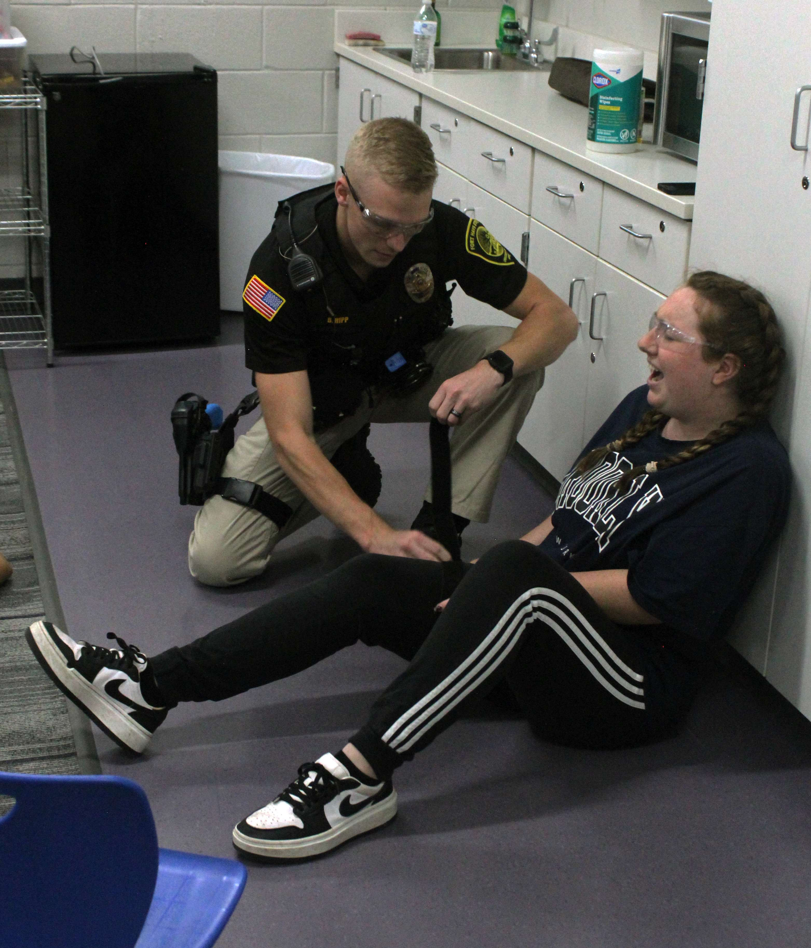 An officer applies a&nbsp;<b>t</b>ourniquet to the leg of a wounded actor during&nbsp;active shooter training on Wednesday at Roosevelt Elementary School. Multiple law enforcement agencies from the area participated in the training. Photo by Cristina Janney/Hays Post