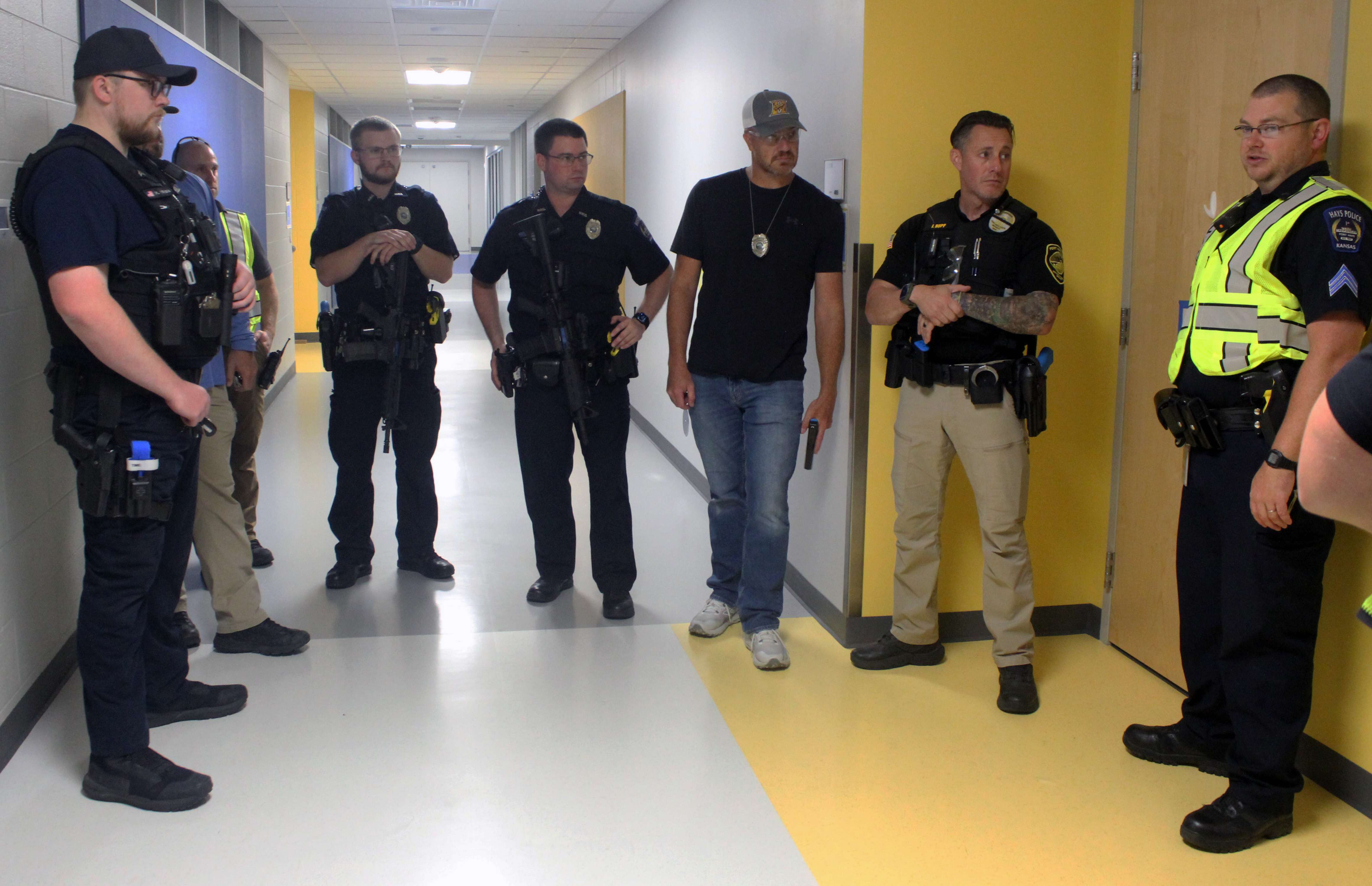 Officers debrief after running an active shooter scenario Wednesday at Roosevelt Elementary School. Officers from the Hays Police Department, Ellis Police Department, Victoria Police Department, Fort Hays State University Police, the Ellis County Sheriff's Office and the Department of Wildlife and Parks participated in the training Wednesday. Photo by Cristina Janney/Hays Post