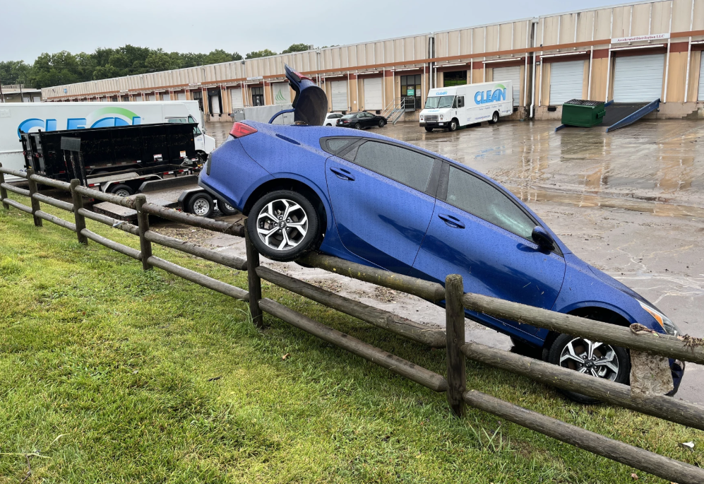 High waters early the morning of July 17, 2025, pushed a car over a fence in Merriam, Kansas. Kansas City firefighters said they executed at least 18 water rescues. Photo by Julie Denesha/KCUR