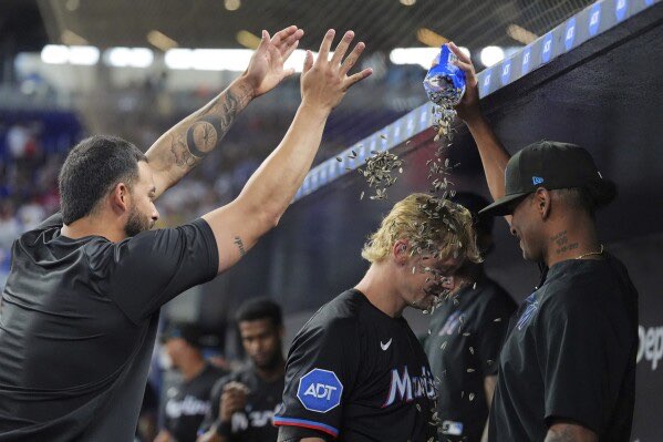 Miami Marlins' Kyle Stowers, center, is celebrated by teammates after hitting a two-run homer in the first inning of a baseball game against the Kansas City Royals, Friday, July 18, 2025, in Miami. (AP Photo/Rebecca Blackwell)