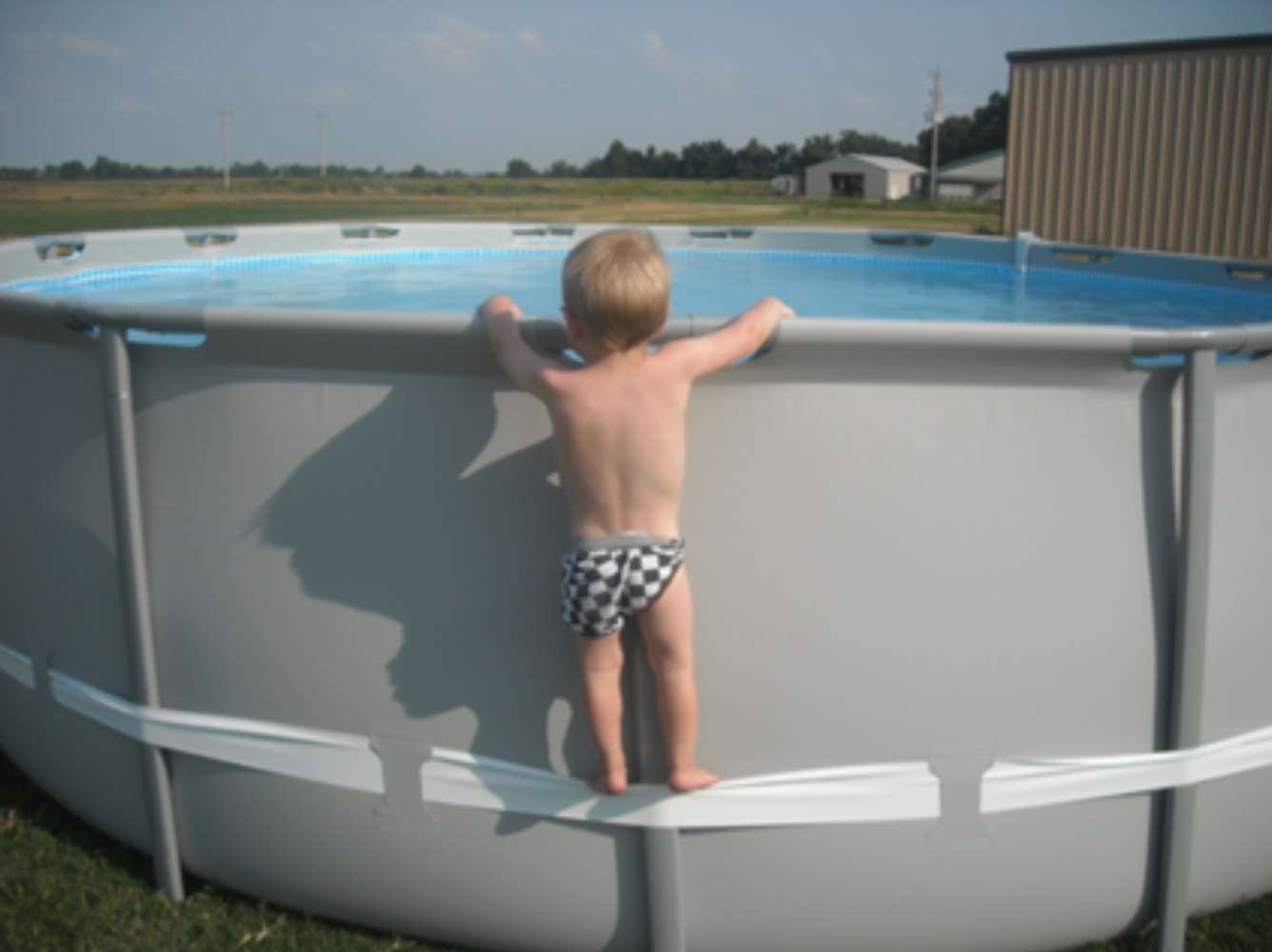 -Example of child using the compression strap to stand on above-ground pool, illustrating the hazard involved.-photo Consumer Product Safety Commission