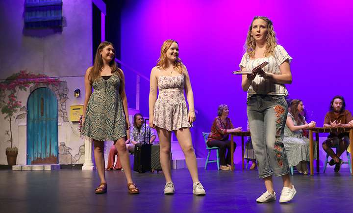 Lisa (Allie Straub) and Ali (McKynlee Stecklein) listen as Sophie (Rebecca Cole) reads from her mom’s diary in Act 1 of Mamma Mia!, which will be presented Thursday-Saturday by Hays Community Theatre at Beach-Schmidt Performing Arts Center. Photo by Bill Gasper/Special to Post