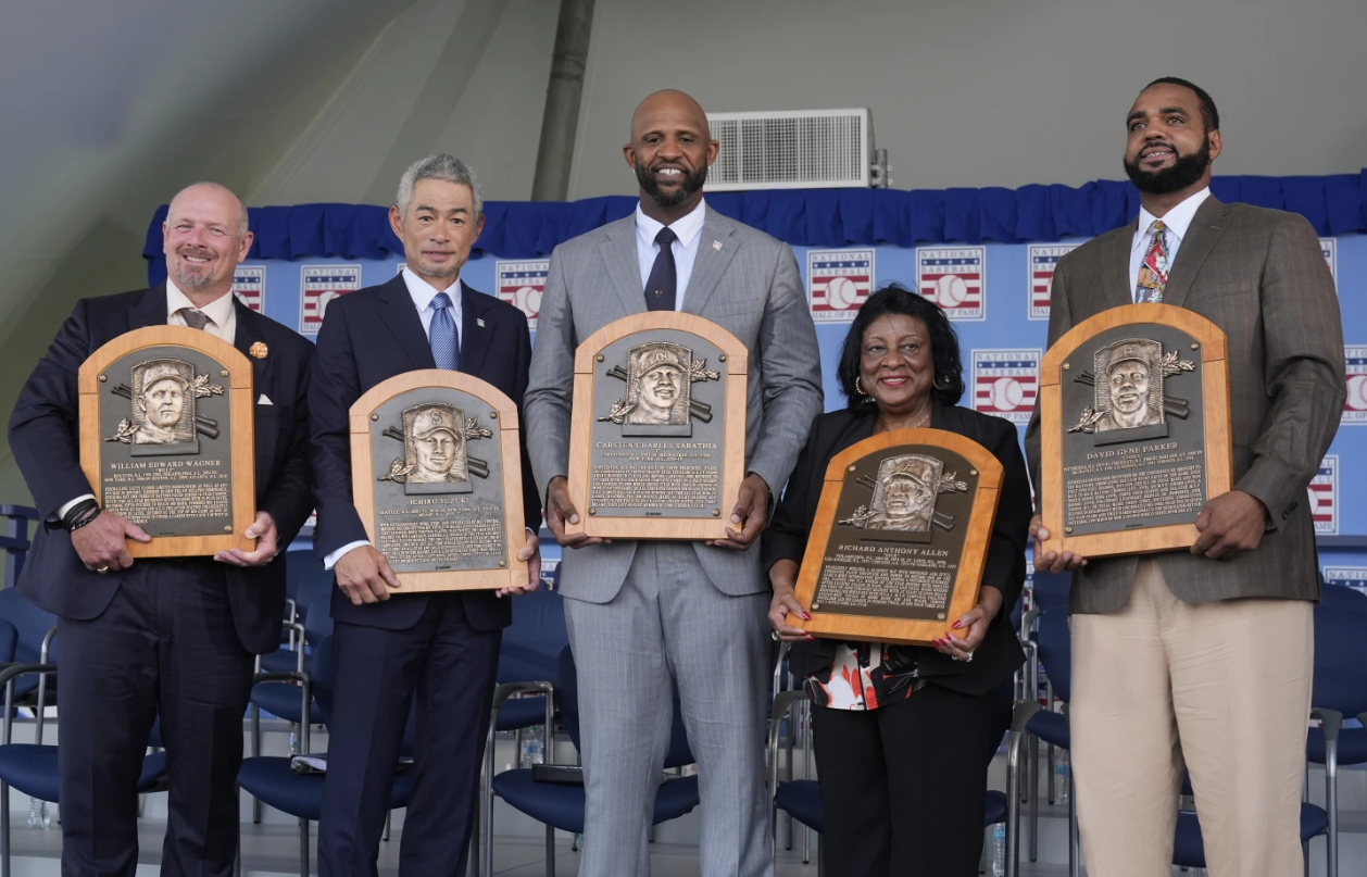 Baseball Hall of Fame inductees Billy Wagner, left, Ichiro Suzuki, second from left, and CC Sabathia, center, pose for a photo with Willa Allen, second from right, widow of Baseball Hall of Fame inductee Dick Allen, and Dave Parker II, right, son of the late Baseball Hall of Fame inductee Dave Parker, at the National Baseball Hall of Fame induction ceremony in Cooperstown, N.Y., Sunday, July 27, 2025. (AP Photo/Seth Wenig)