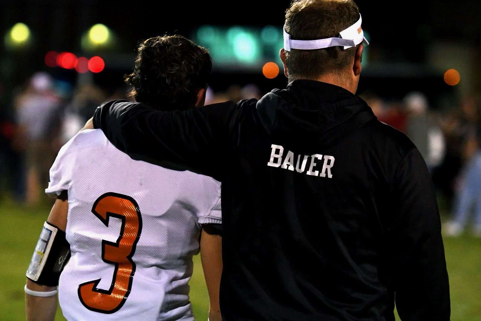 Bauer embraces his player as coach of Ogallala football (photo credit Harry Lipsea, Keith County News)