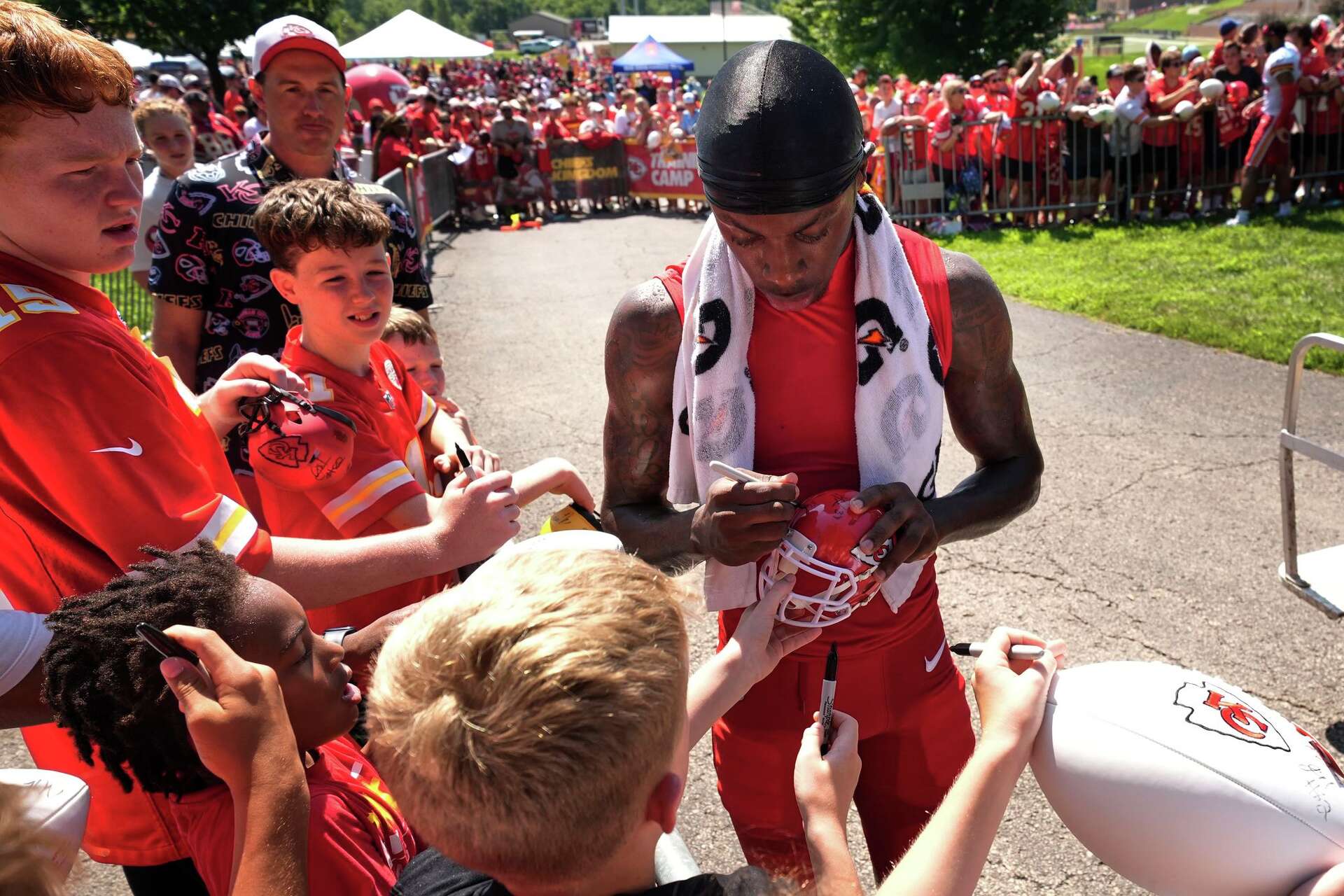 Kansas City Chiefs wide receiver Xavier Worthy signs autographs during Back Together Weekend at the team's NFL football training camp, Sunday, July 27, 2025, in St. Joseph, Mo. (AP Photo/Charlie Riedel)