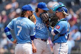 Kansas City Royals shortstop Bobby Witt Jr. (7), relief pitcher Hunter Harvey, center, and Freddy Fermin meet on the mound during the sixth inning of a baseball game against the Atlanta Braves Wednesday, July 30, 2025, in Kansas City, Mo. (AP Photo/Charlie Riedel)