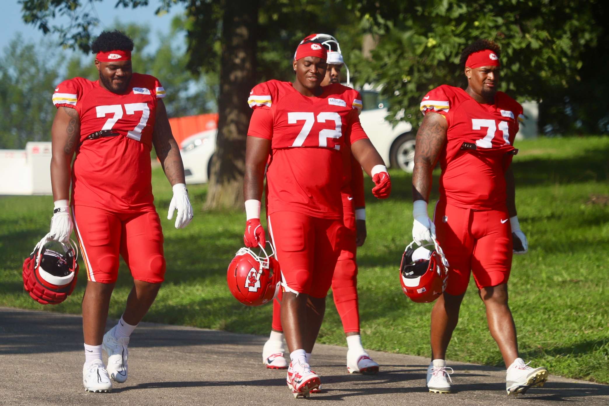 Offensive tackle Jaylon Moore (77) walks down the hill alongside fellow offensive lineman Chukwuebuka Godrick (72) and rookie Josh Simmons (71)/ Photo by Alexis Starks