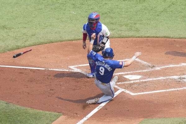 Kansas City Royals first base Vinnie Pasquantino (9) scores in front Toronto Blue Jays catcher Alejandro Kirk after a sacrifice fly from Royals' Mike Yastrzemski during the fourth inning of a baseball game in Toronto on Sunday Aug. 3, 2025. (Chris Young/The Canadian Press via AP)