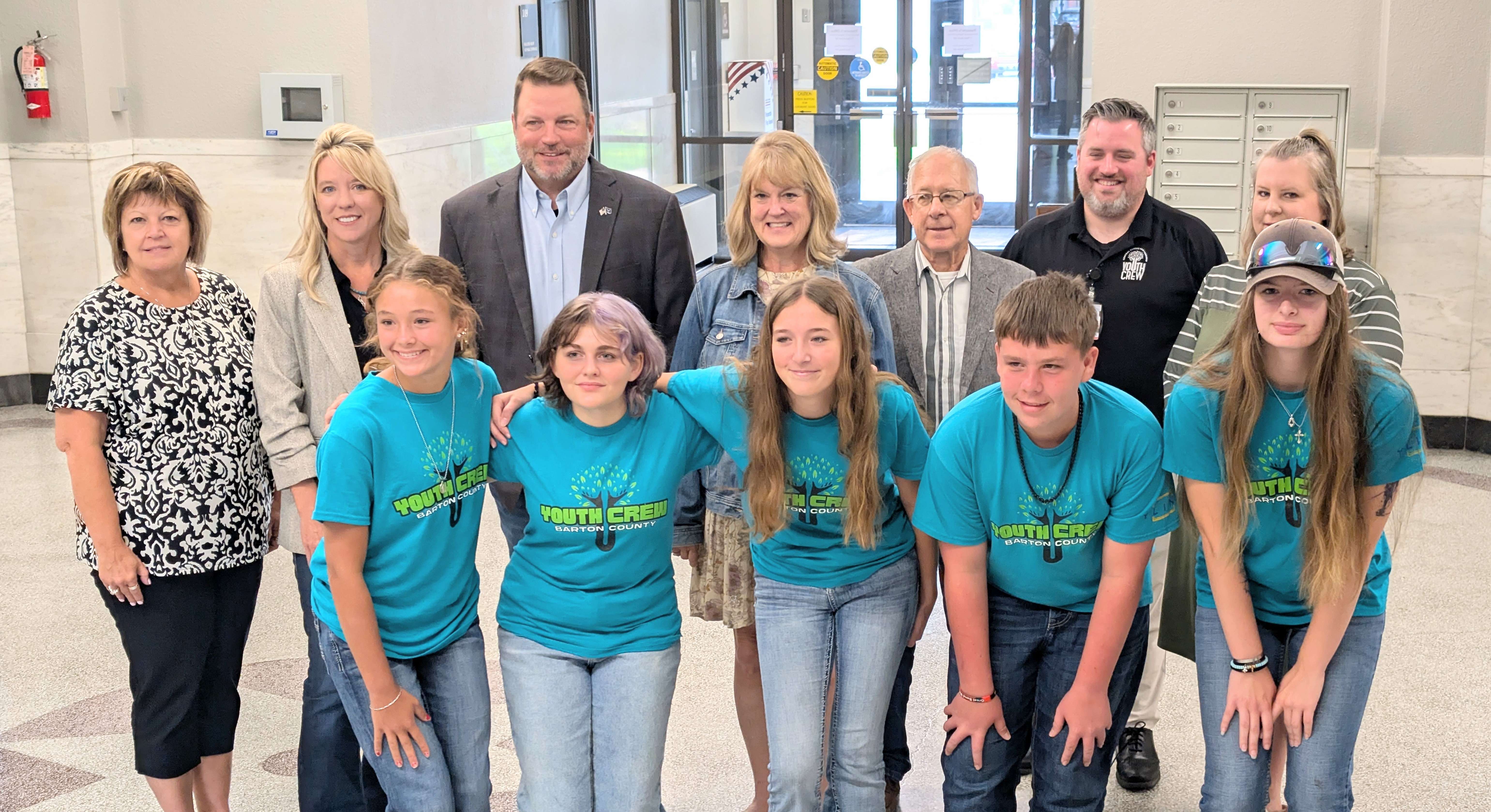 Members of the Barton County Youth Crew and their sponsors who attended a training in Nashville, Tenn., last month, pose with Barton County commissioners Tuesday morning after making their presentation.