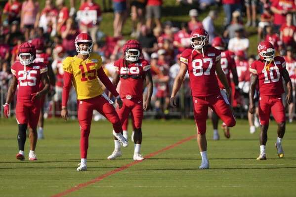 Kansas City Chiefs quarterback Patrick Mahomes (15) and tight end Travis Kelce (87) stretch with teammates at NFL football training camp Tuesday, Aug. 5, 2025, in St. Joseph, Mo. (AP Photo/Charlie Riedel)