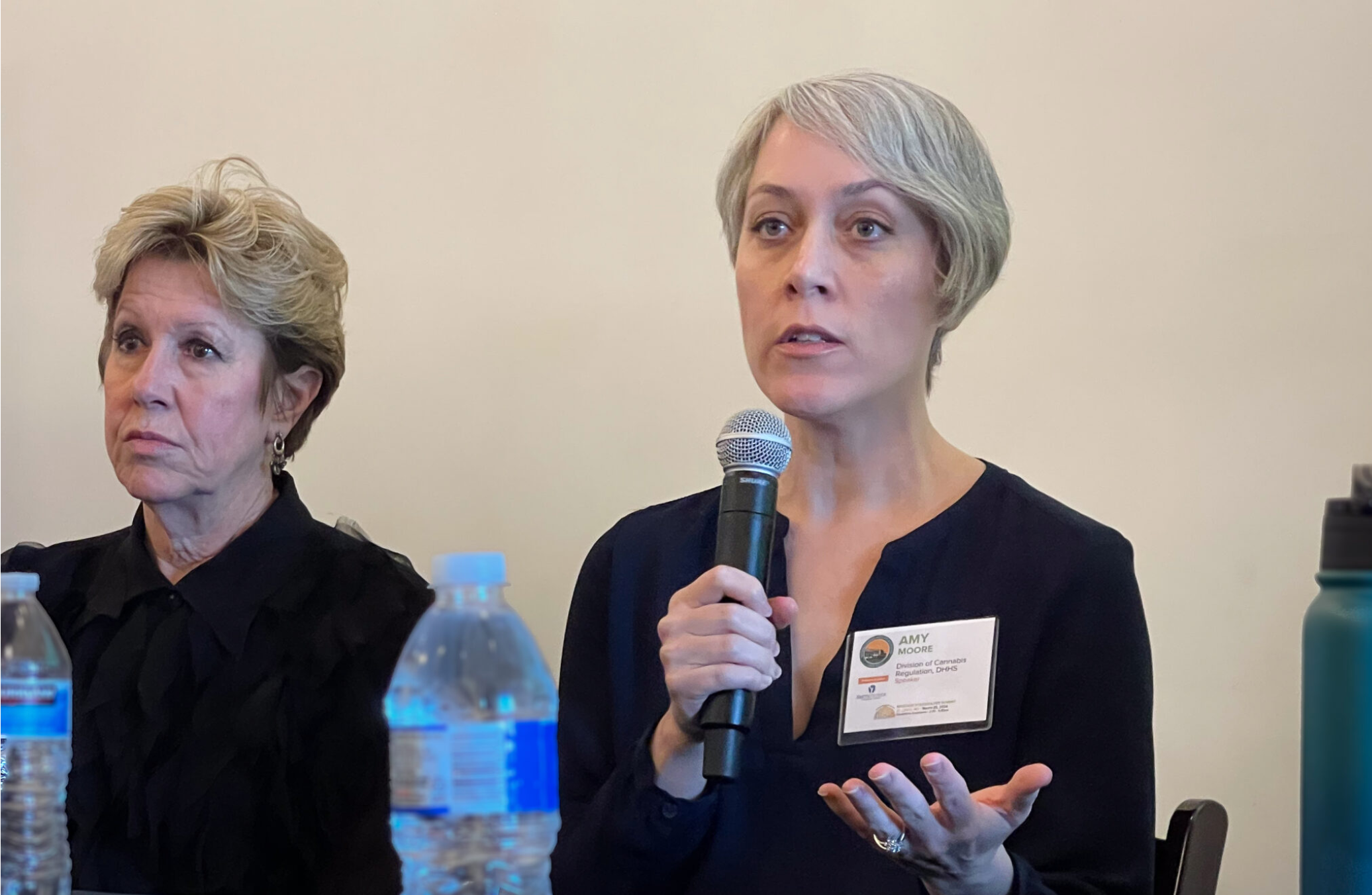 Amy Moore, (right) director of the Missouri Division of Cannabis Regulation, speaks at the National Cannabis Industry Association’s summit on March 28 in St. Louis. At left is Mitch Meyers, partner at BeLeaf Medical marijuana company (Rebecca Rivas/Missouri Independent).
