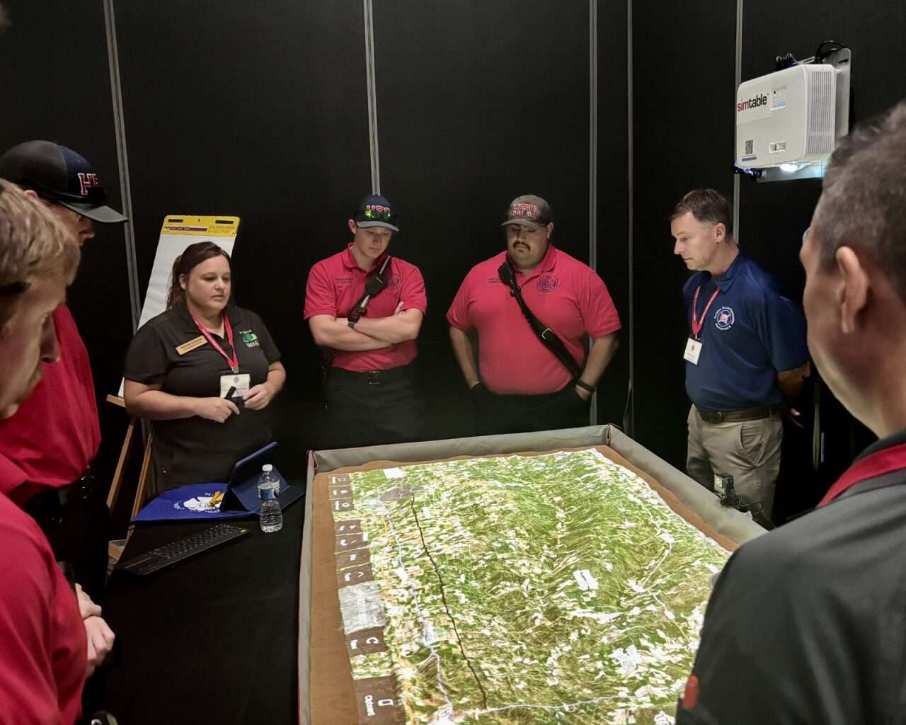 Hays Fire Fighters and other officials gathered around a SimTable at the Wildland Resilience Summit in Hays. Photo by Tony Guerrero/Hays Post
