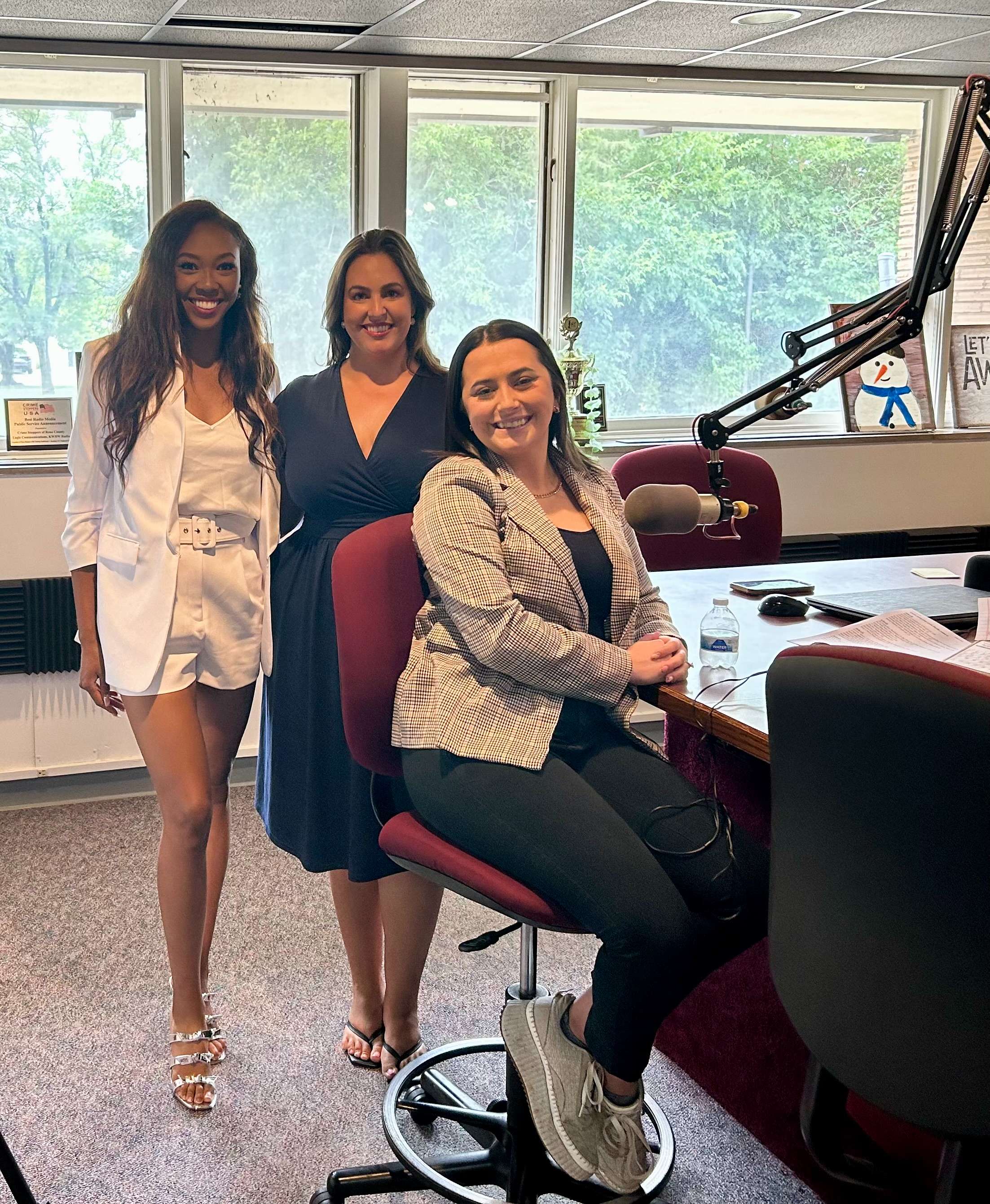 From left, Asia Cymone Smith, KSN-TV sports anchor/reporter; Micaela Dea, KAKE-TV sports director; and Rachel Hallam, KWCH-TV multimedia journalist, pose in the KWBW Radio studio in Hutchinson, Kan., on Monday, Aug. 18, 2025, during an interview marking the first Women in Sports Broadcasting Day in Kansas.