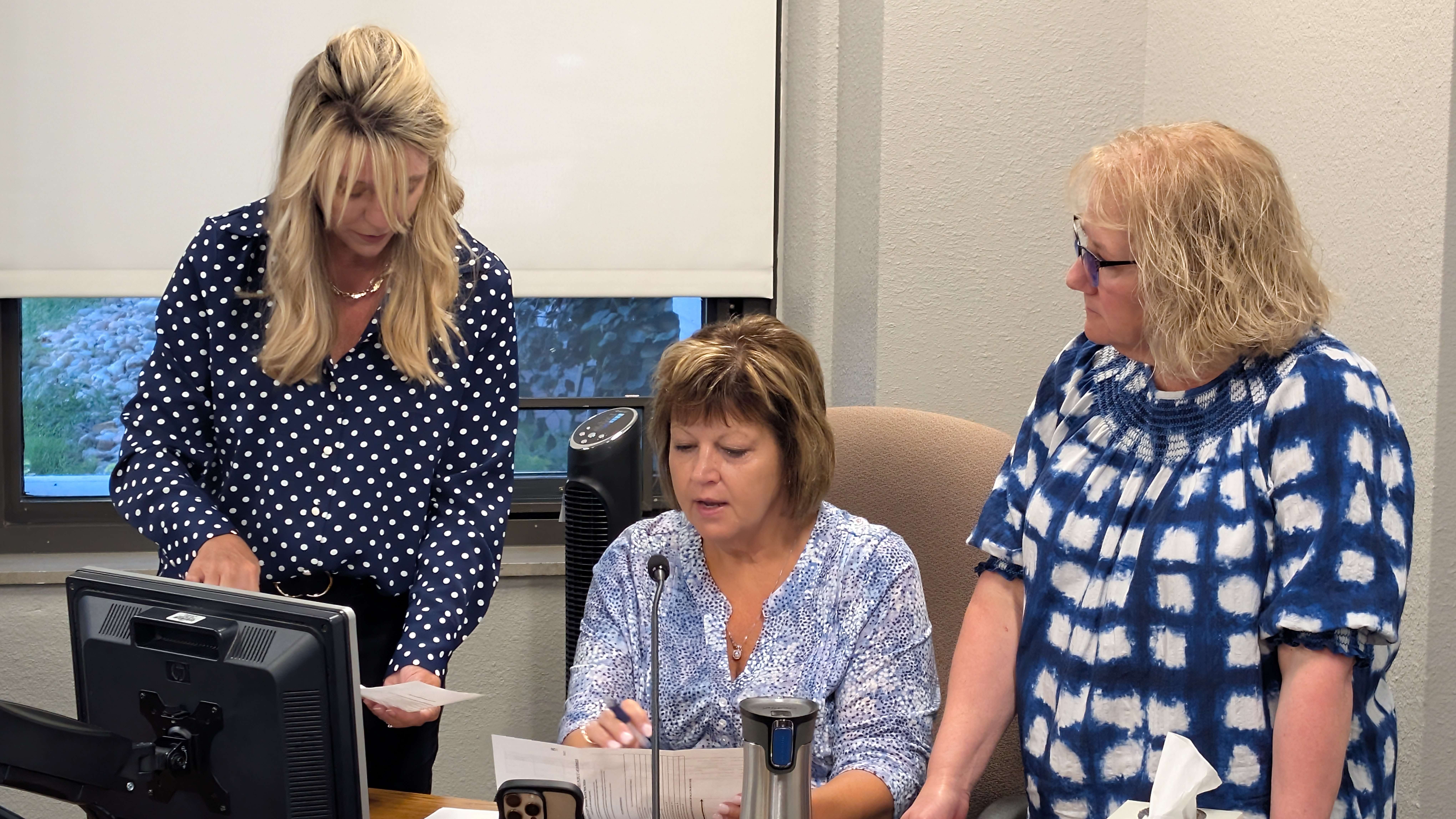 Barton County Commissioners Tricia Schlessiger, left, and Donna Zimmerman, center, discuss the confusion over the recently mailed revenue-neutral rate notices with County Clerk Bev Schmeidler following the commission meeting Tuesday morning.