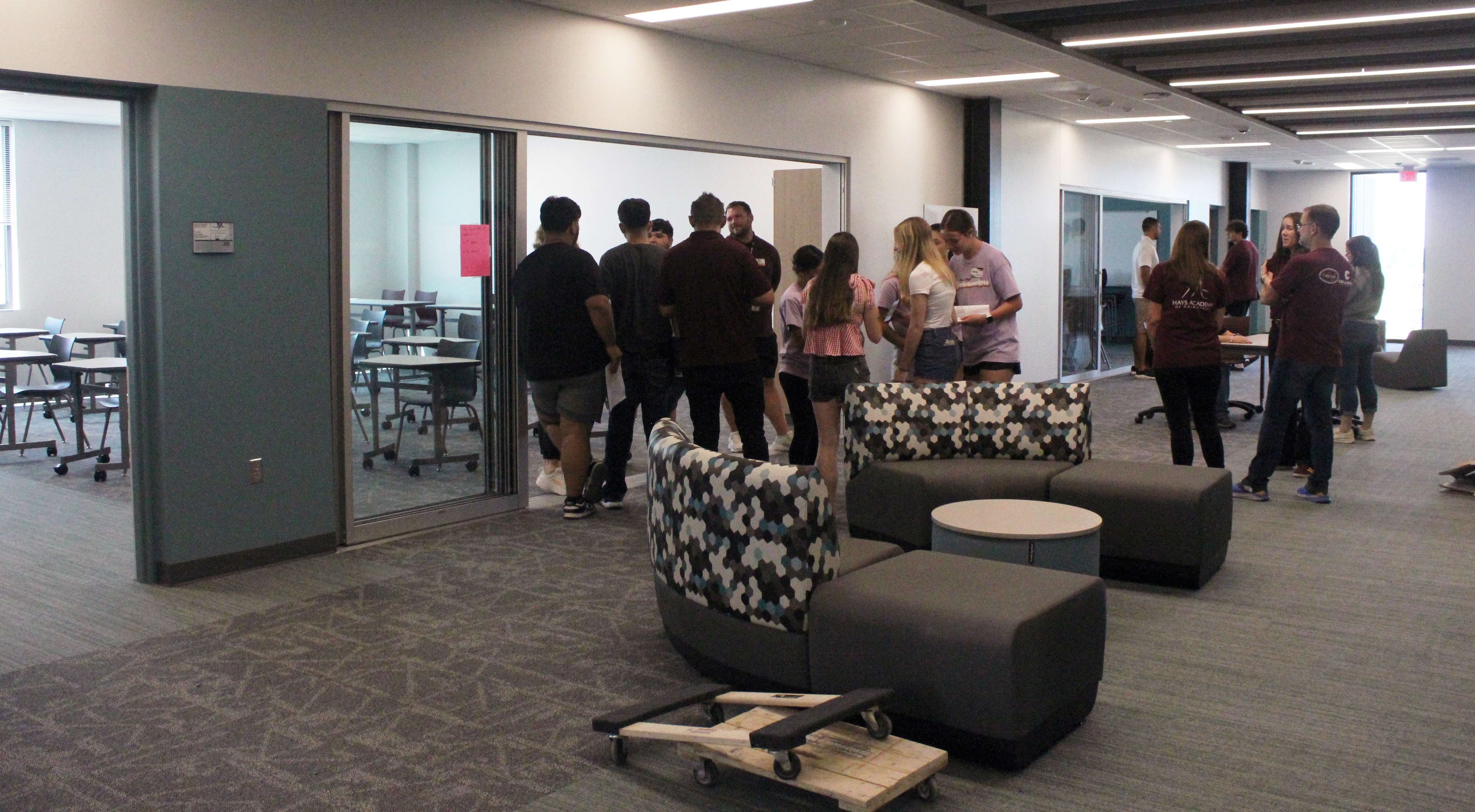 Students and teachers gather in the hall of the English wing of the new Hays High. The halls have flexible seating so students can work in small groups. Glass doors allow light in and teachers to monitor students working in the hallways. Photo by Cristina Janney/Hays Post