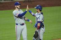 Texas Rangers' Jonah Heim, left, and Kyle Higashioka celebrate after their baseball game against the Kansas City Royals, Wednesday, Aug. 20, 2025, in Kansas City, Mo. (AP Photo/Charlie Riedel)