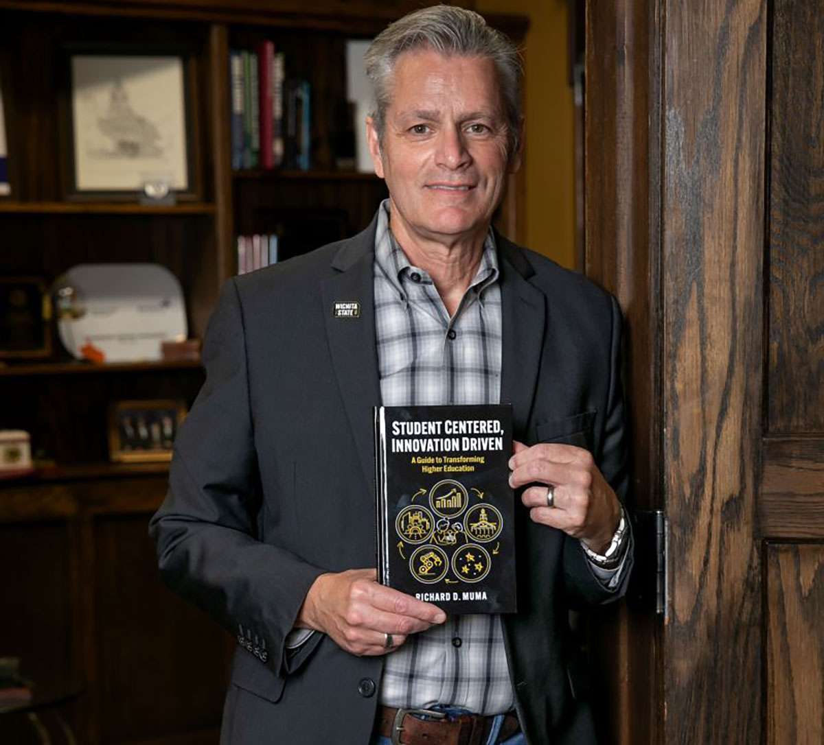 WSU President Rick Muma holding new book "Student Centered, Innovative Driven." Release date is Tuesday, August 26 across bookstores. Courtesy of Wichita State University